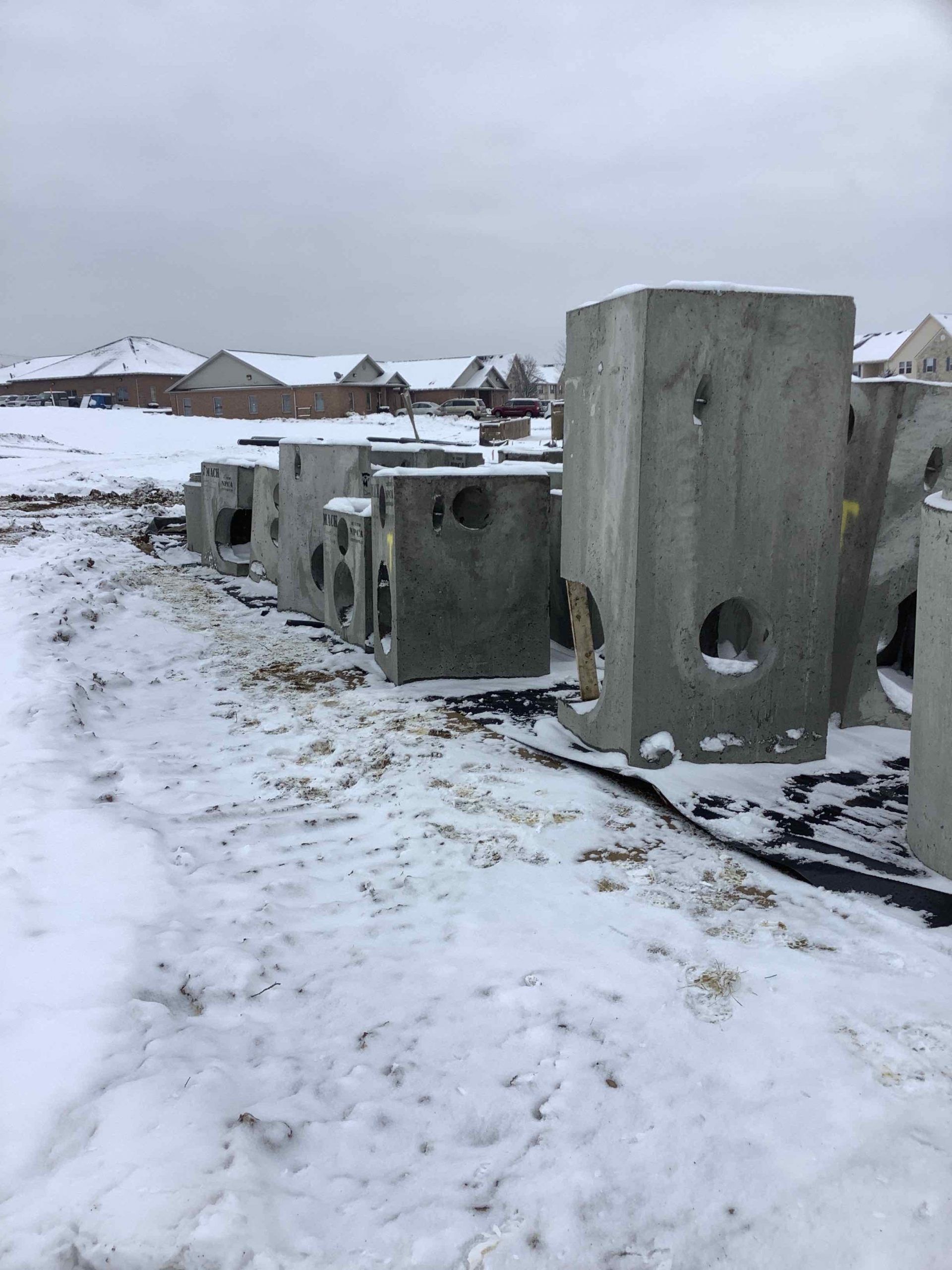 A row of concrete blocks sitting on top of a snow covered field.