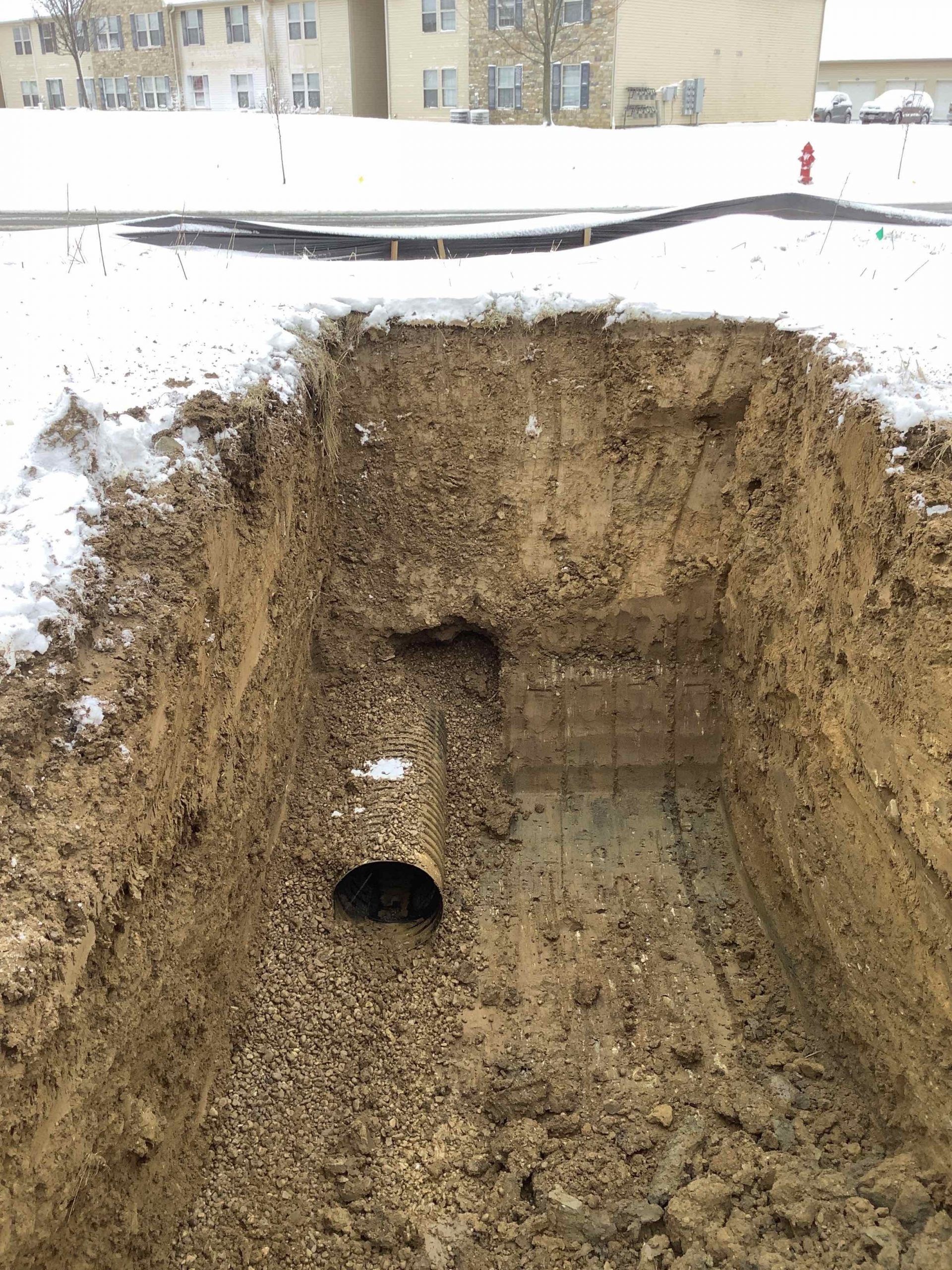 A large hole in the ground with a pipe in it.