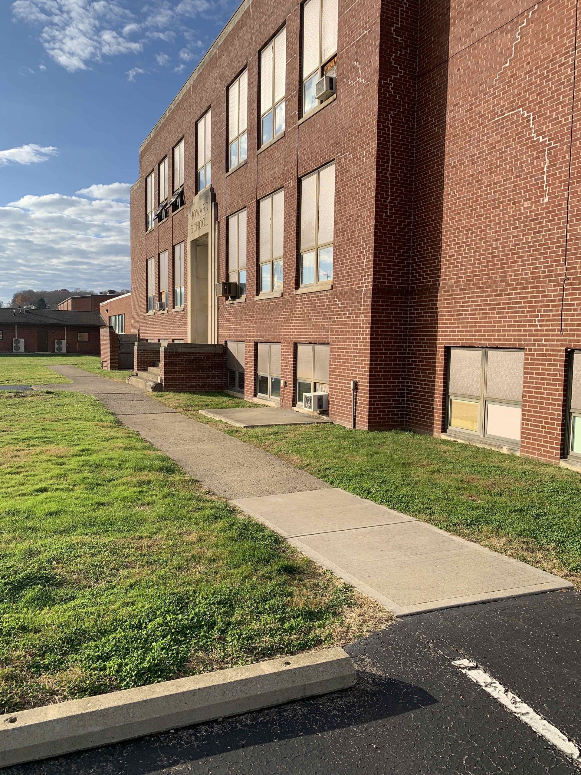 A large brick building with a sidewalk in front of it.