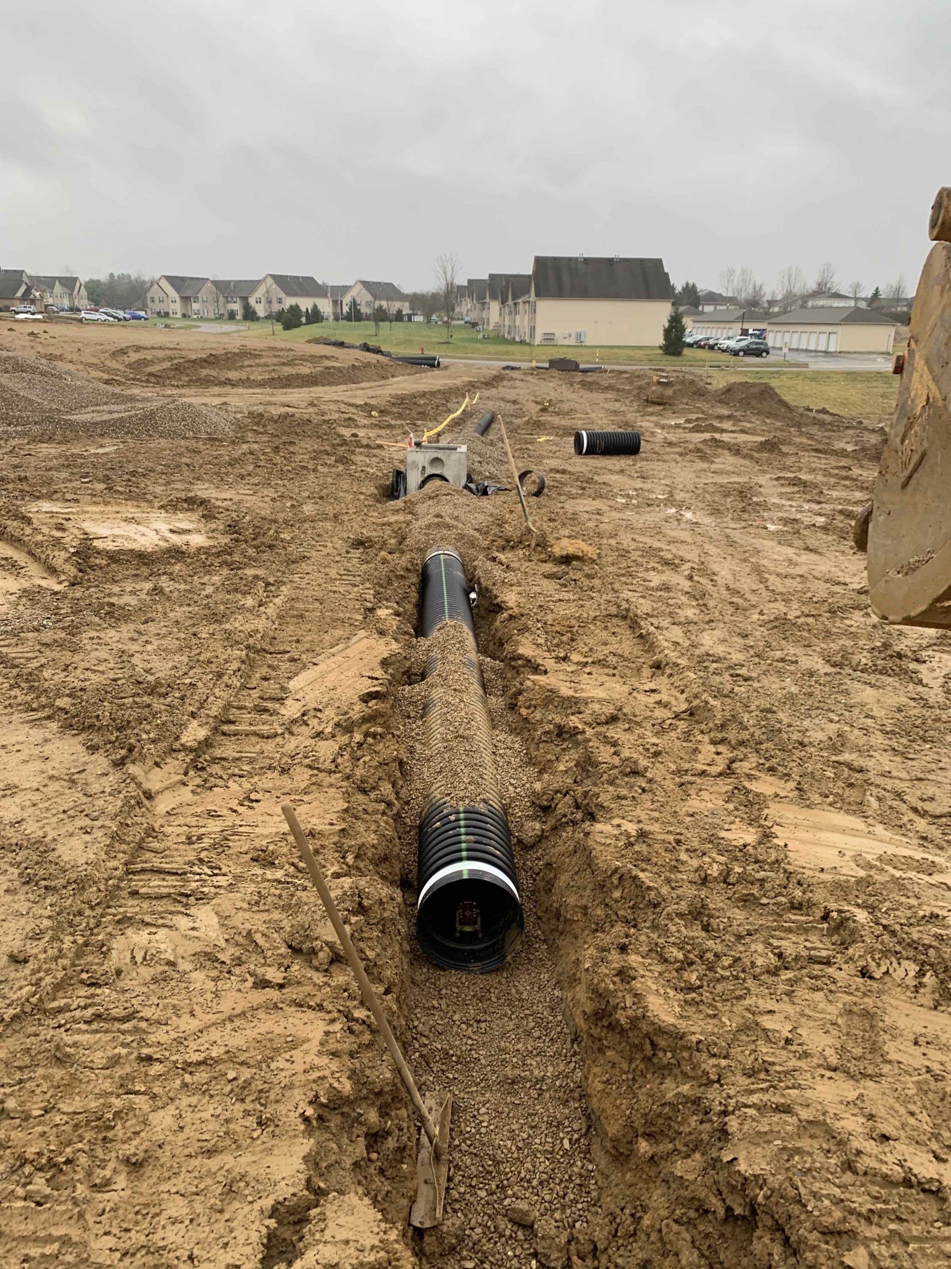 A large pipe is sitting in the middle of a dirt field.