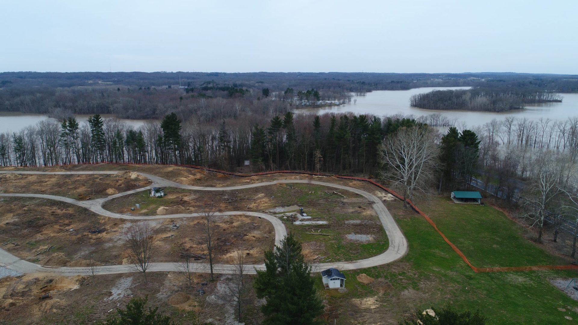 An aerial view of a park with a lake in the background.