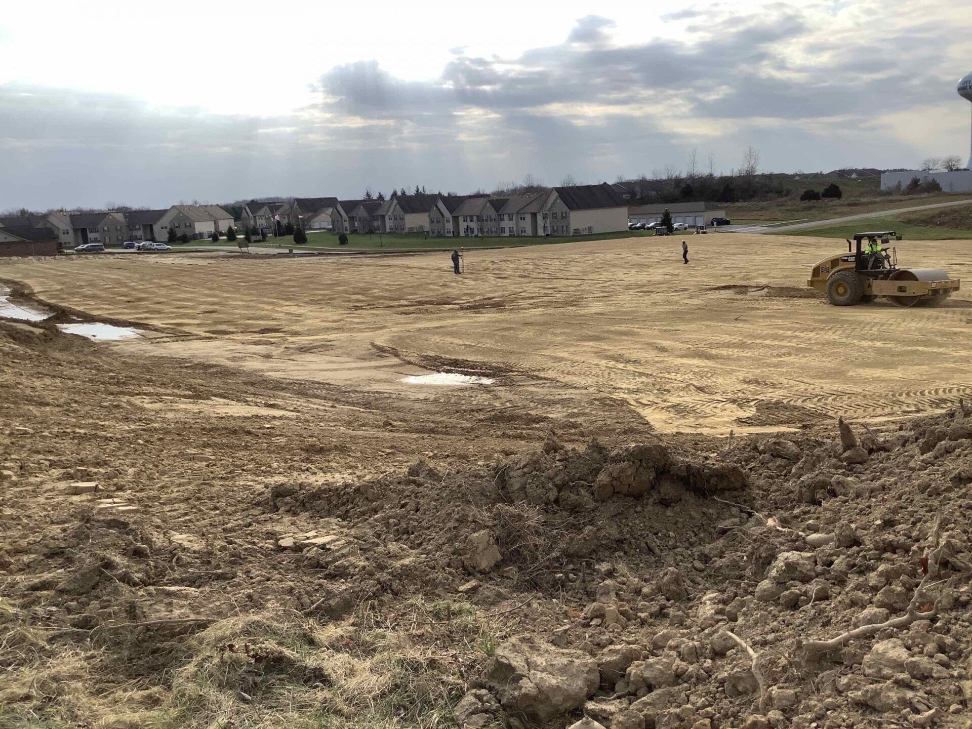 A large dirt field with a tractor in the middle of it.