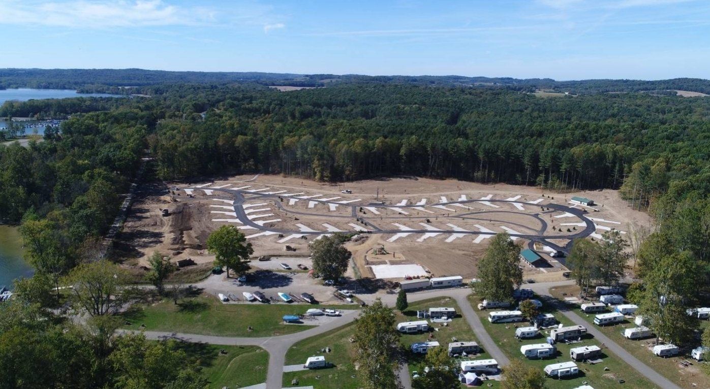 An aerial view of a campground surrounded by trees and a lake.