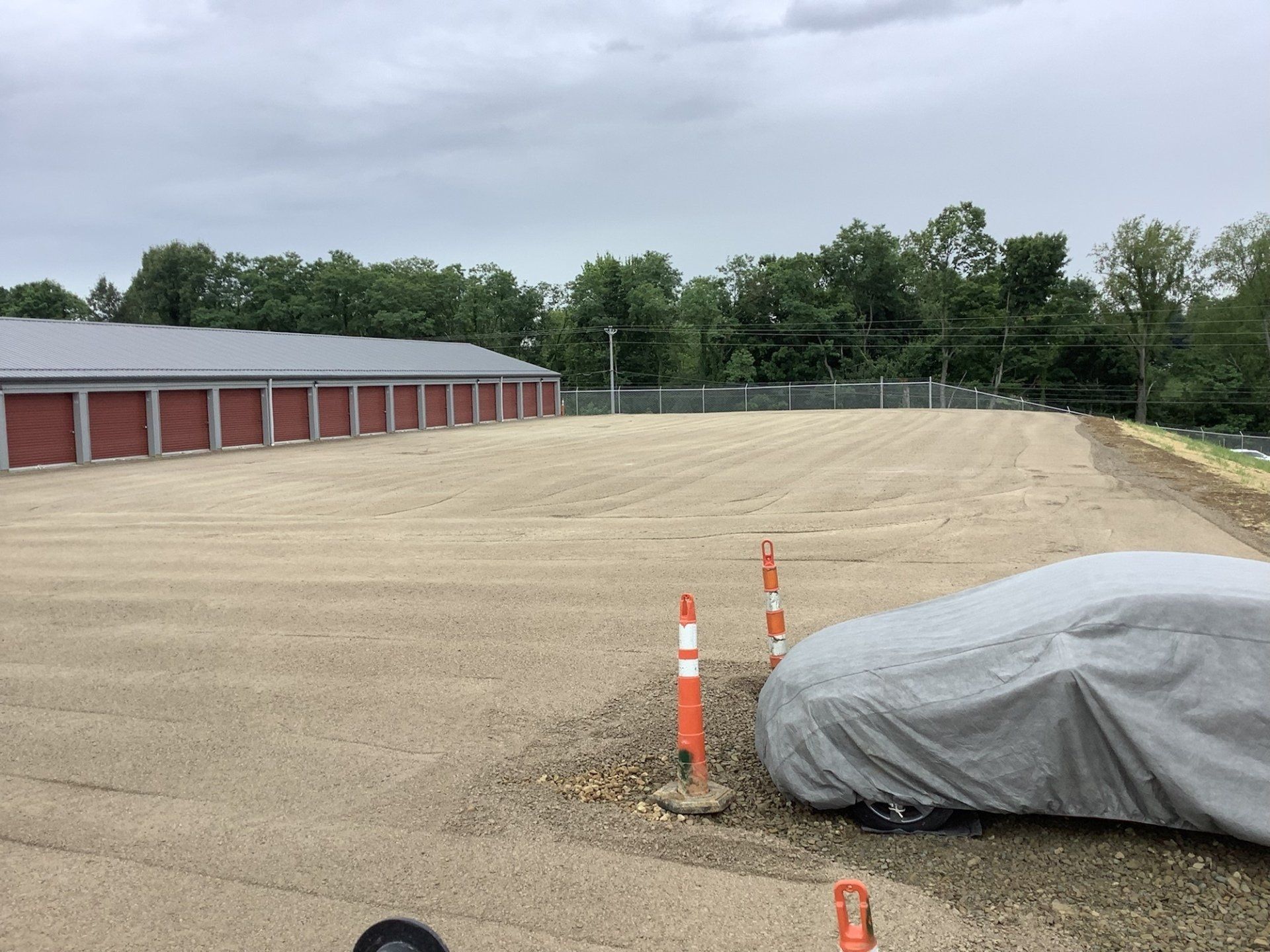 A car with a cover on it is parked in a parking lot.
