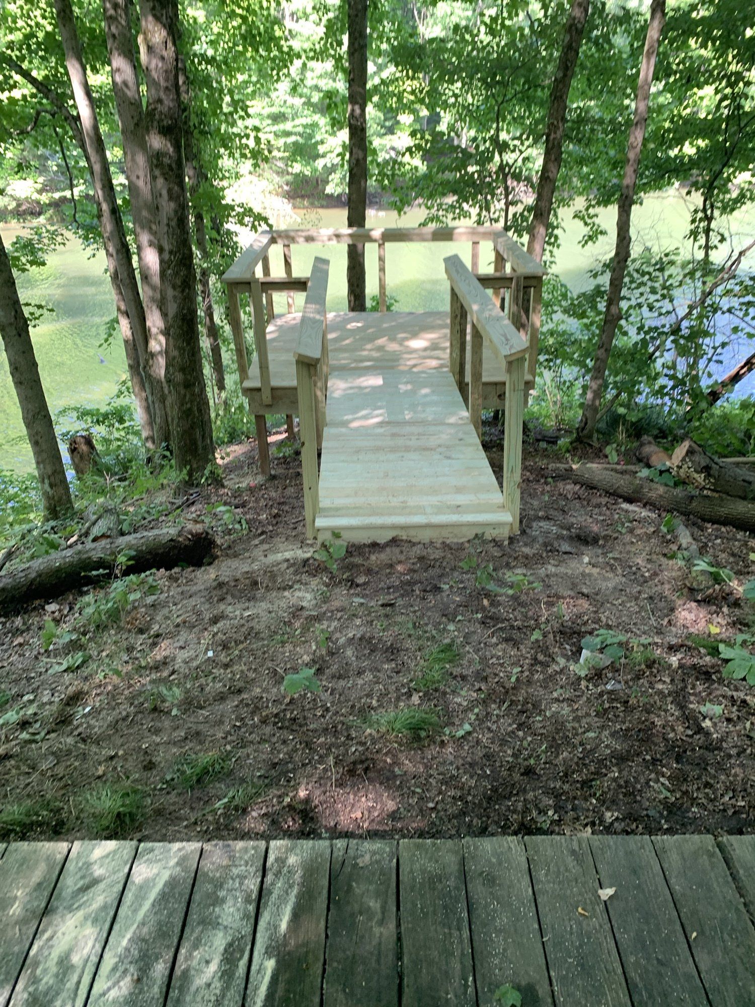 A wooden bridge over a body of water in the woods.