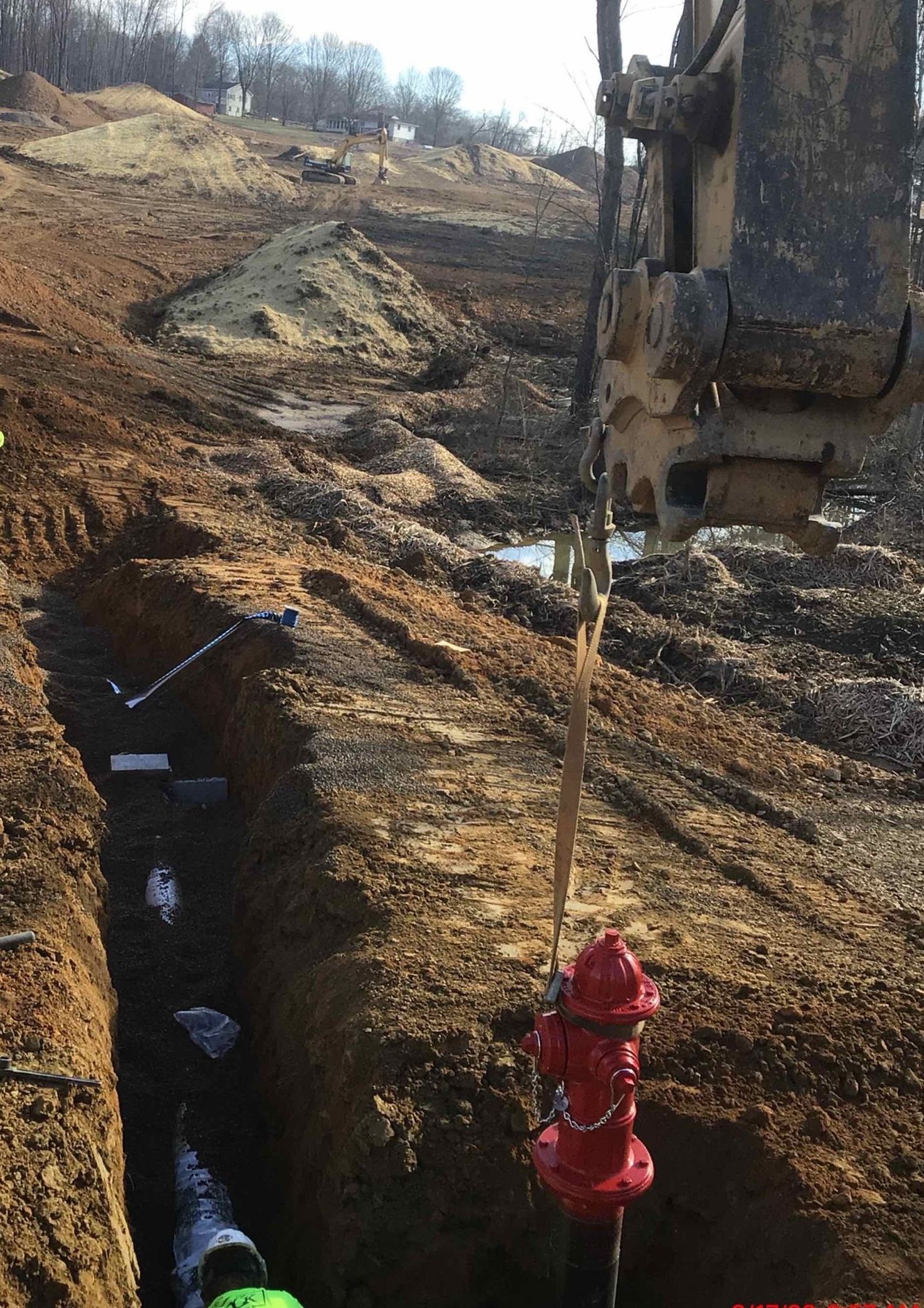 A fire hydrant is being installed in a hole in the ground.