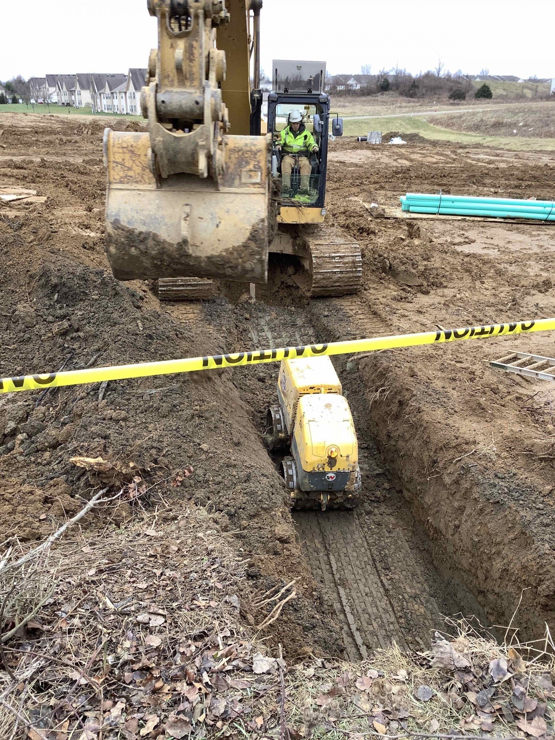 A bulldozer is digging a hole in the dirt in a construction site.