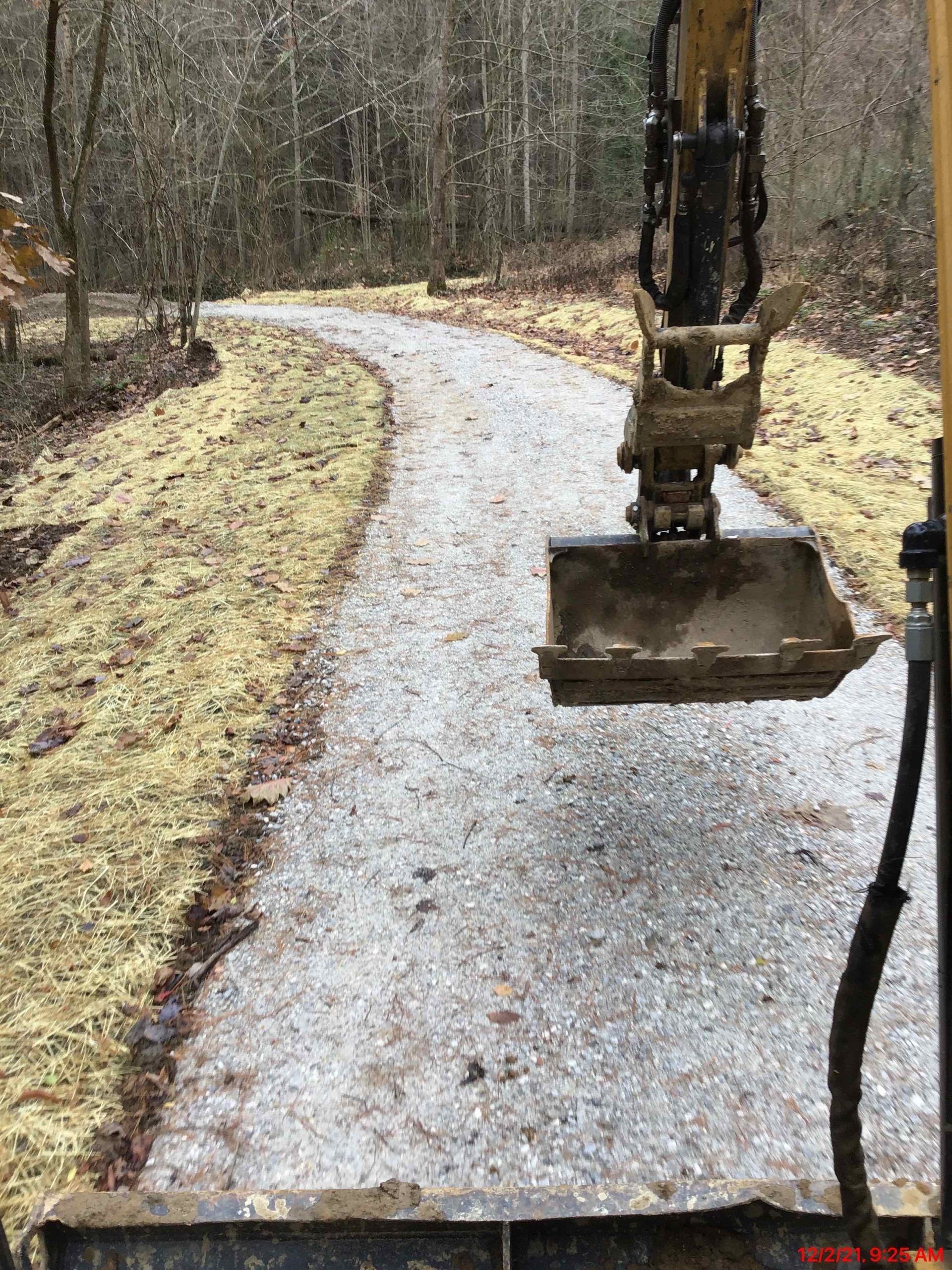 A bulldozer is digging a path in the woods.
