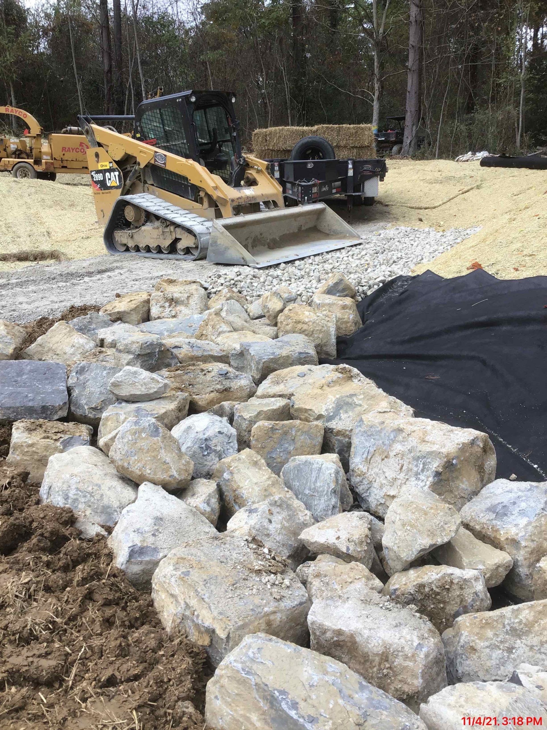 A bulldozer is sitting on top of a pile of rocks.