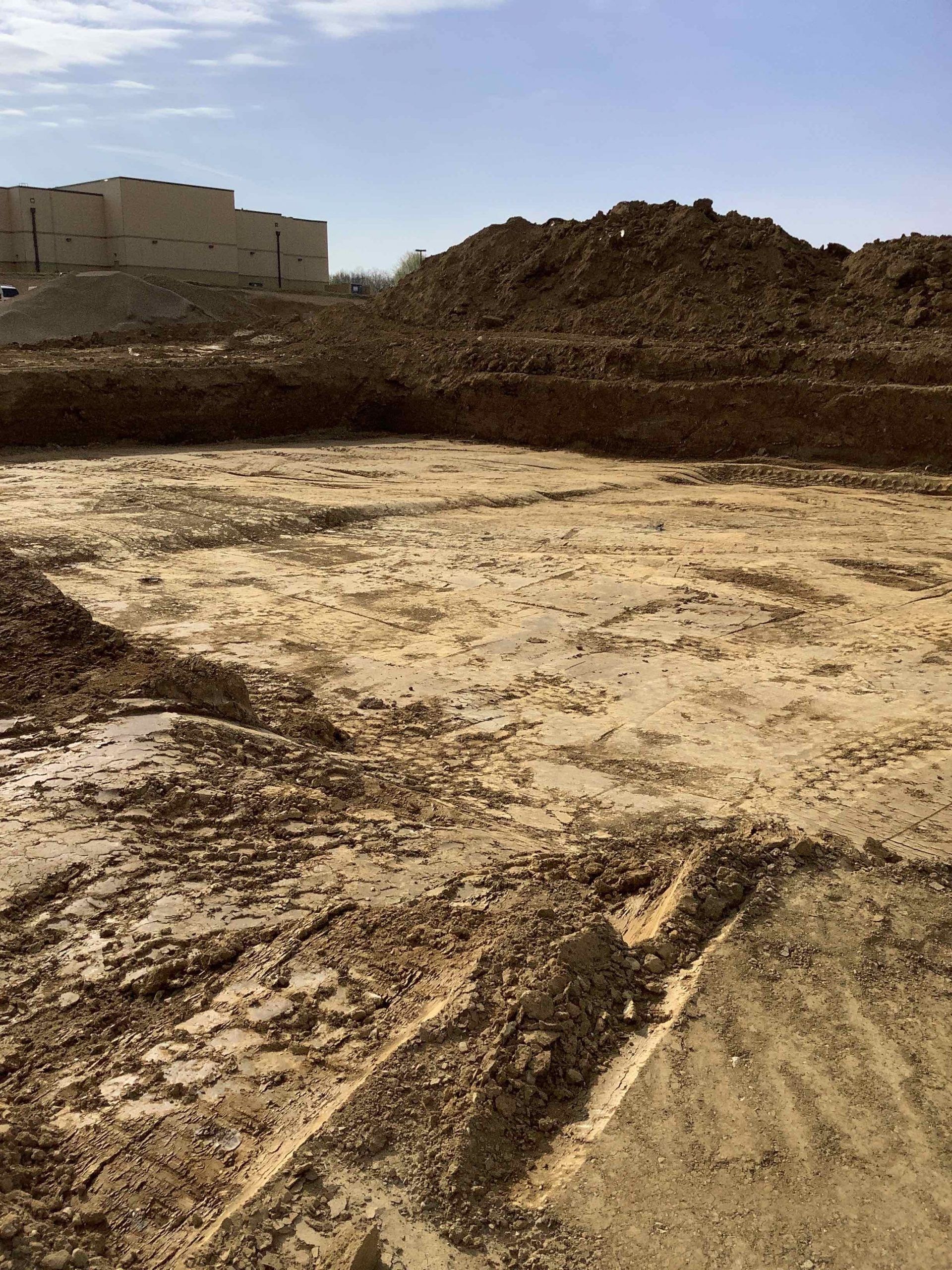 A large pile of dirt is sitting in the middle of a muddy field.