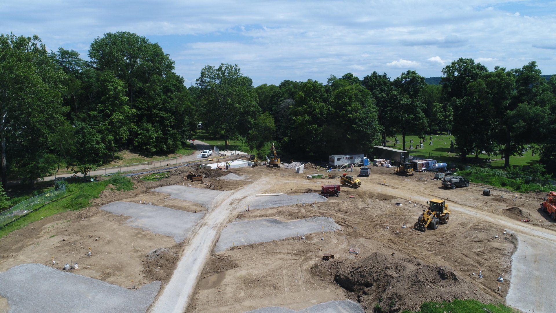 An aerial view of a construction site with trees in the background