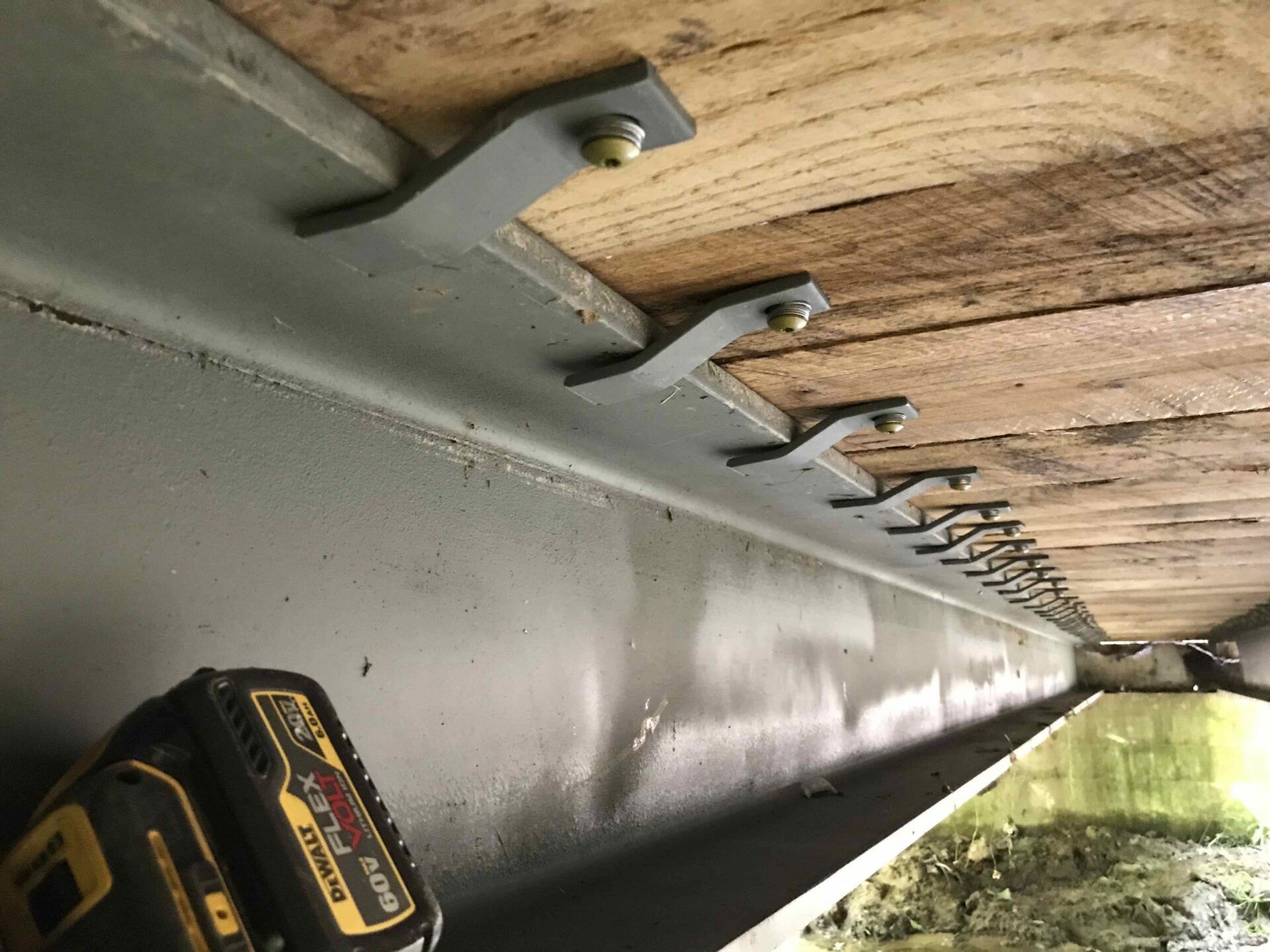 A dewalt battery is sitting next to a piece of wood.