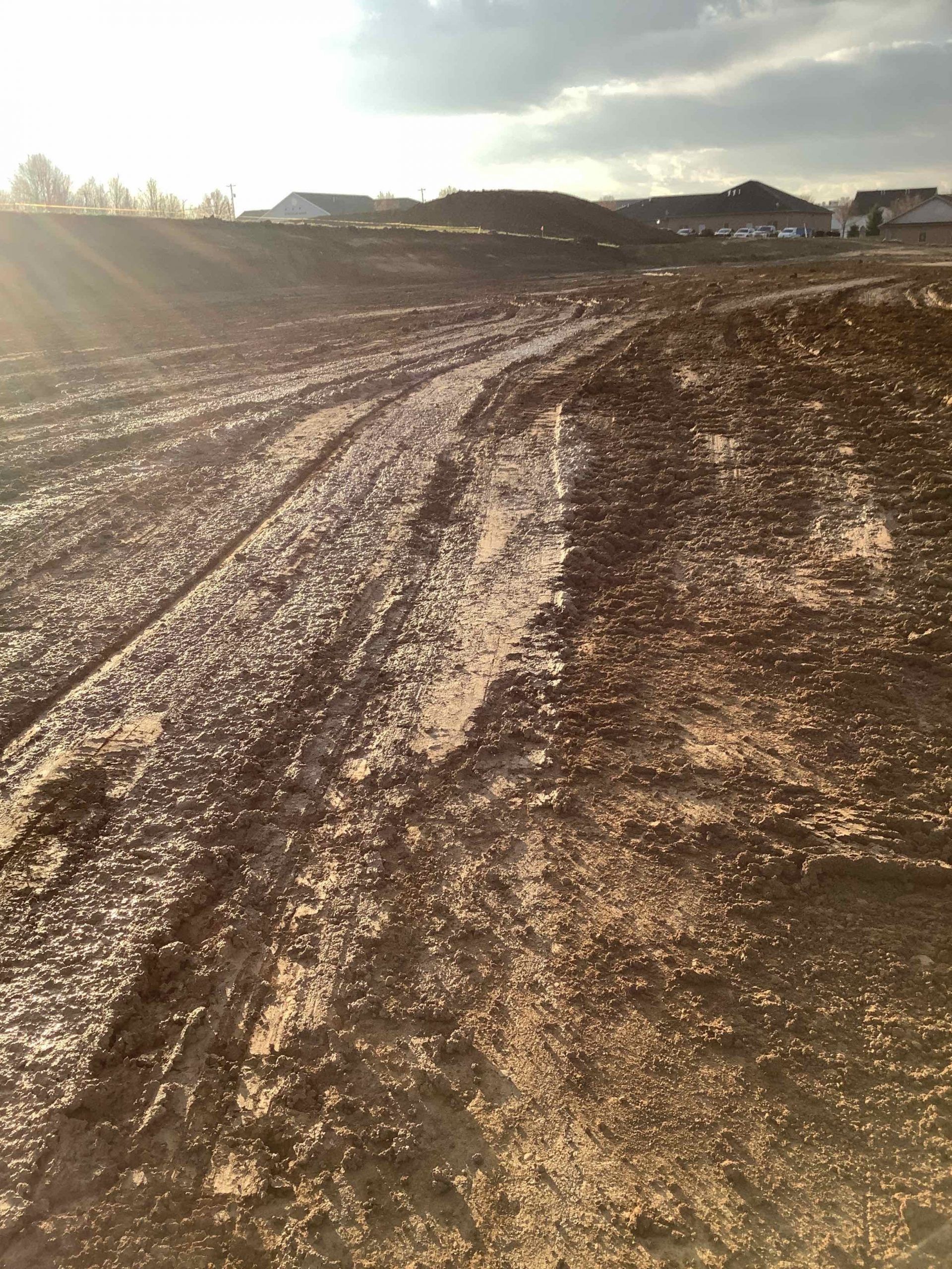 A muddy field with a lot of tire tracks in it
