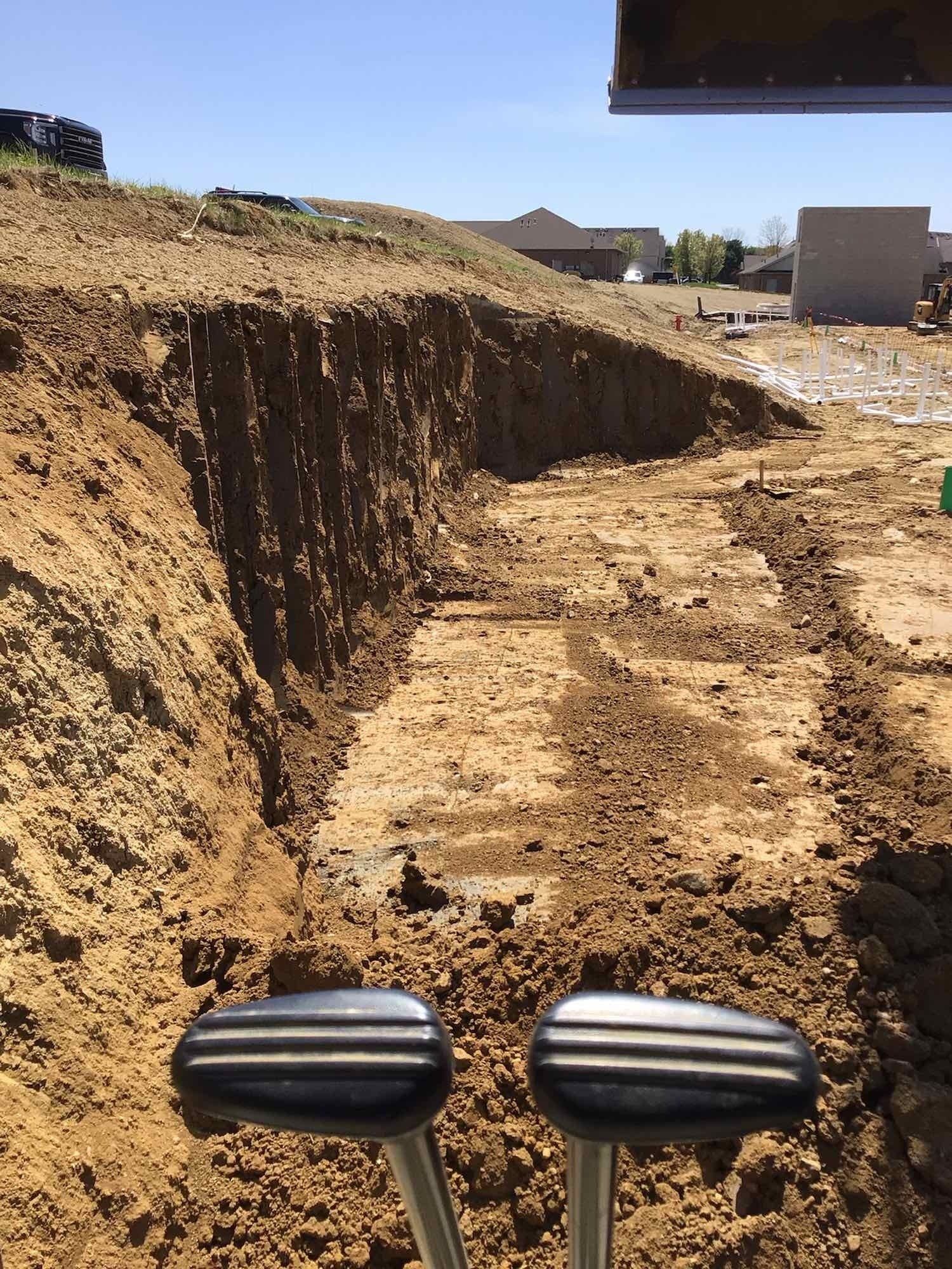 A bulldozer is digging a hole in the dirt on a construction site.