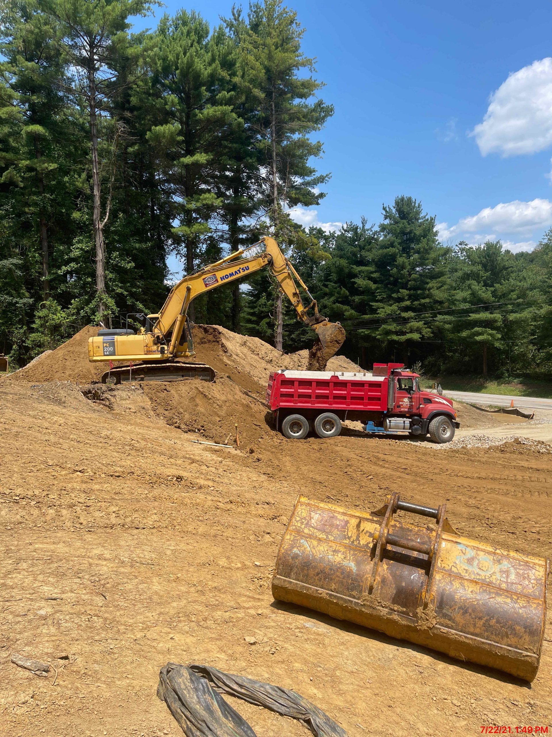 A dump truck is being loaded with dirt in a construction site.