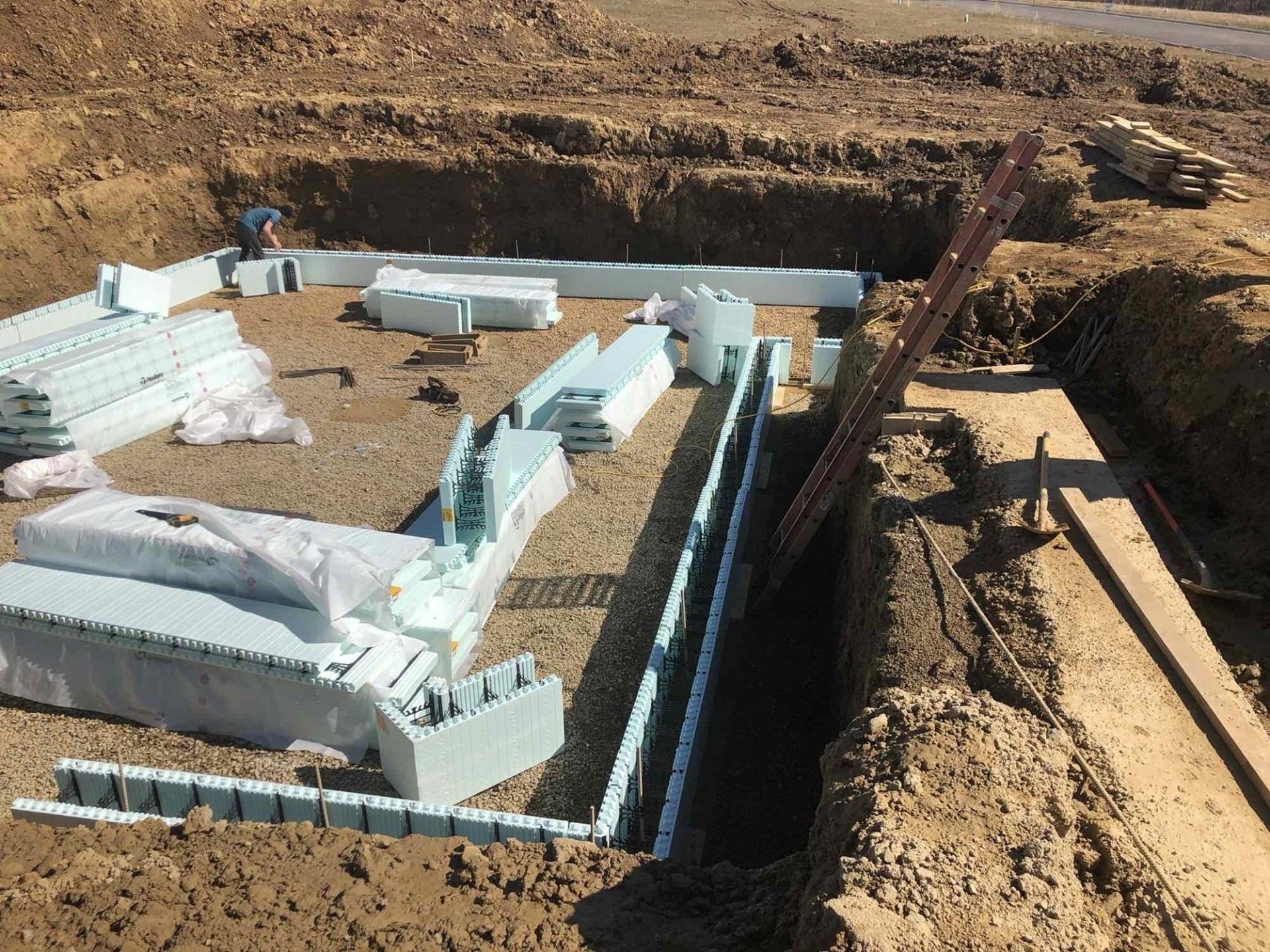 A large pile of styrofoam blocks is sitting on top of a dirt field.