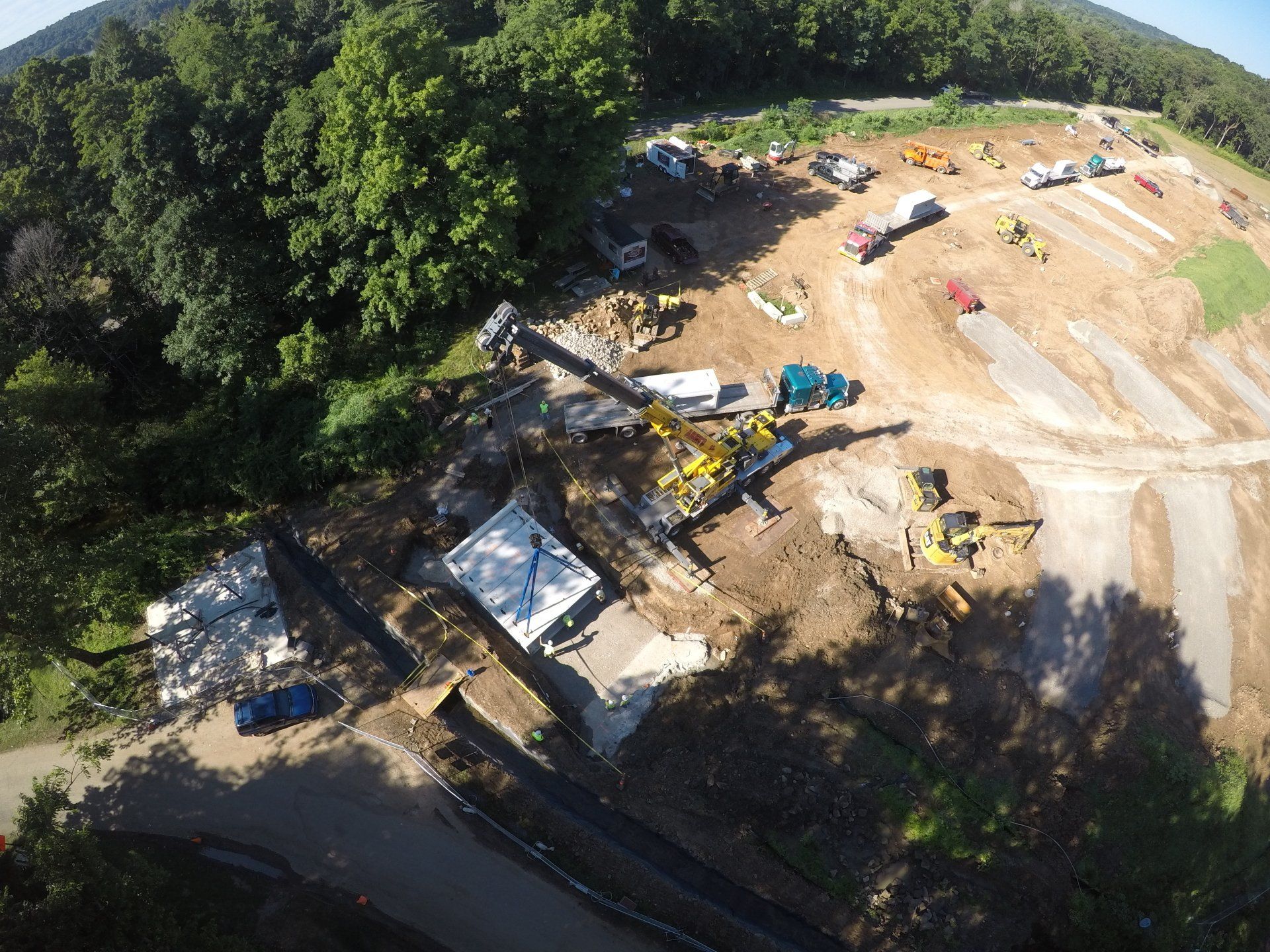 An aerial view of a construction site with trees in the background