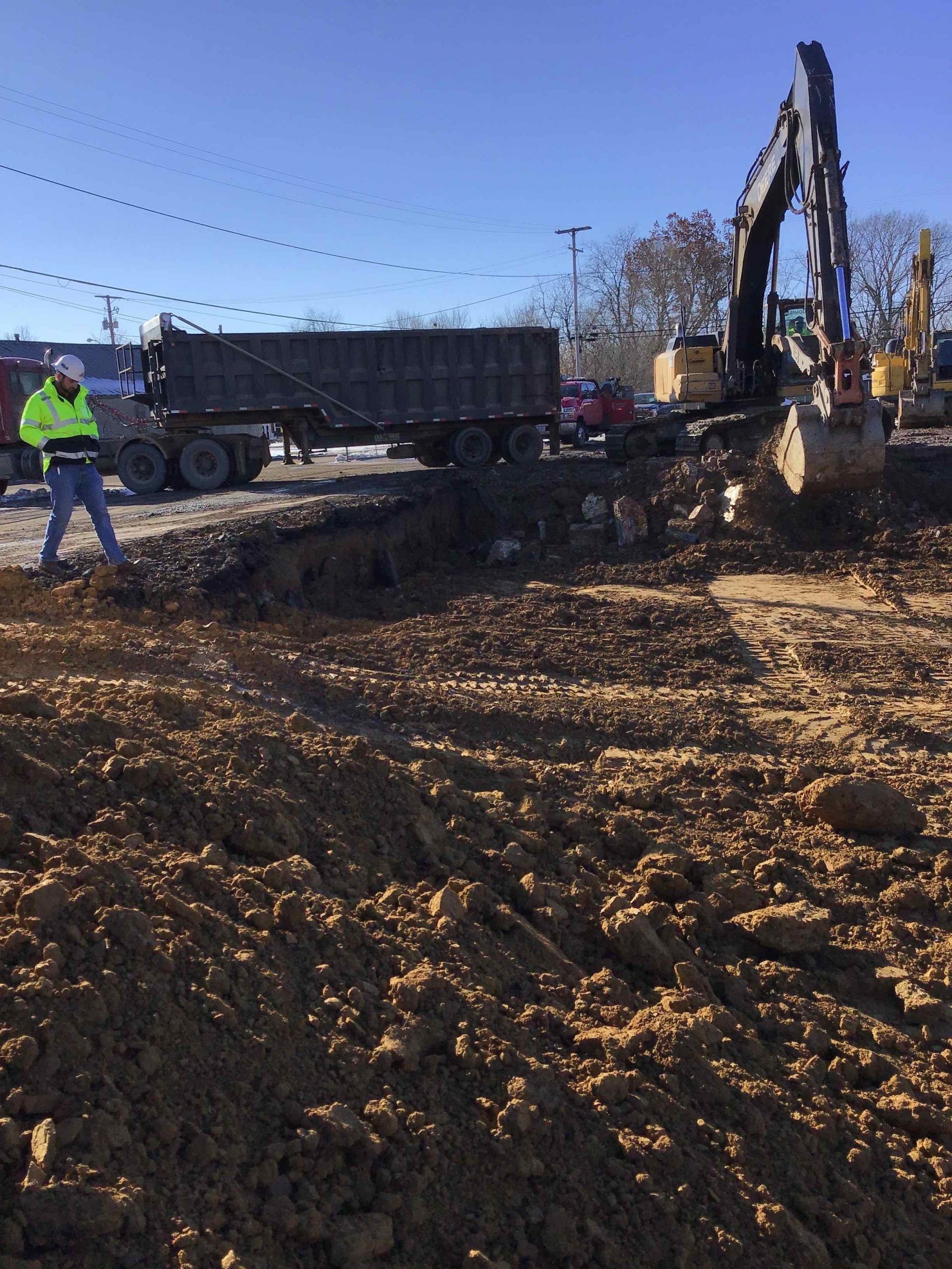 A construction site with a dump truck and a bulldozer in the background.