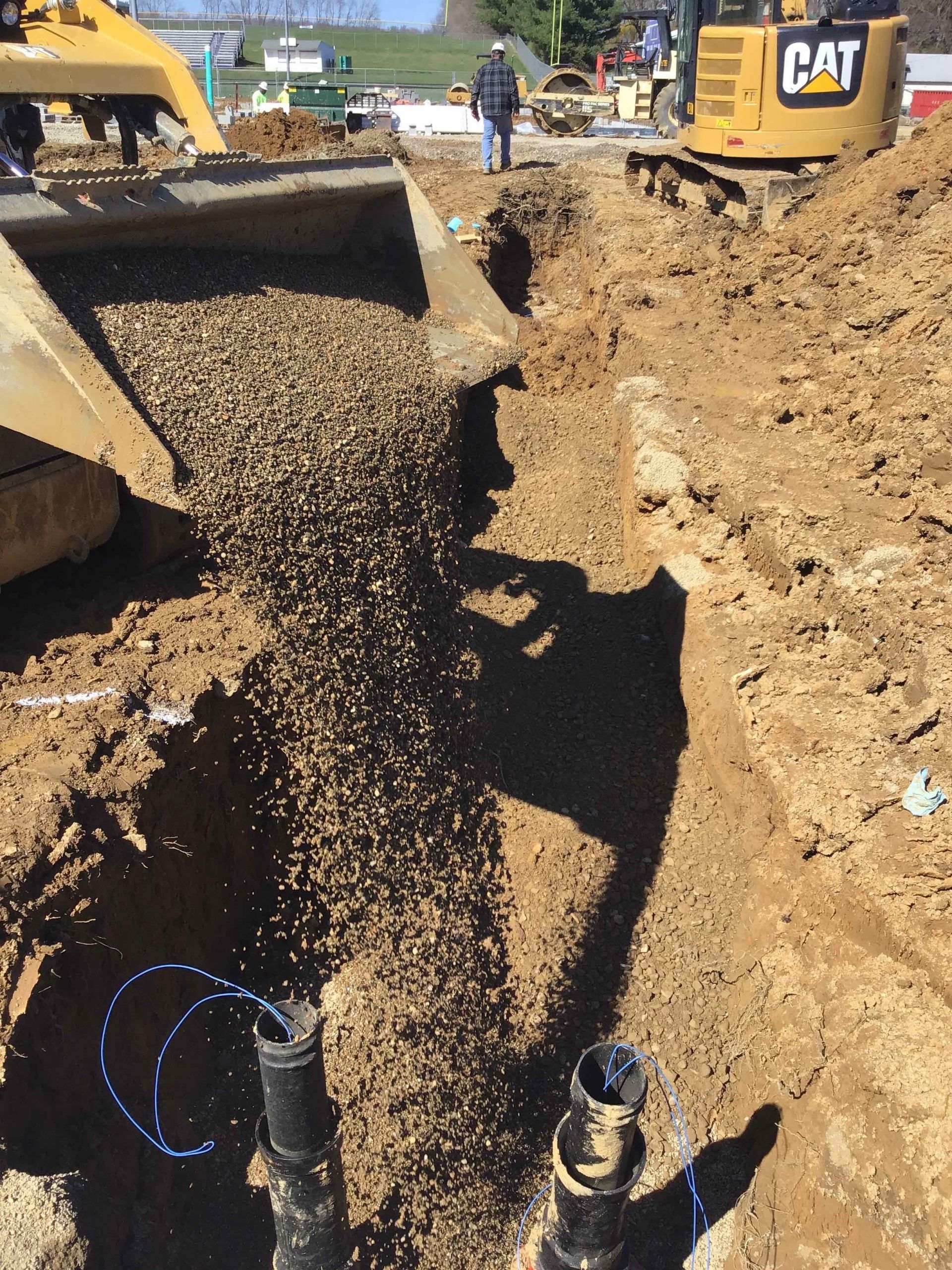 A cat bulldozer is digging a hole in the dirt.