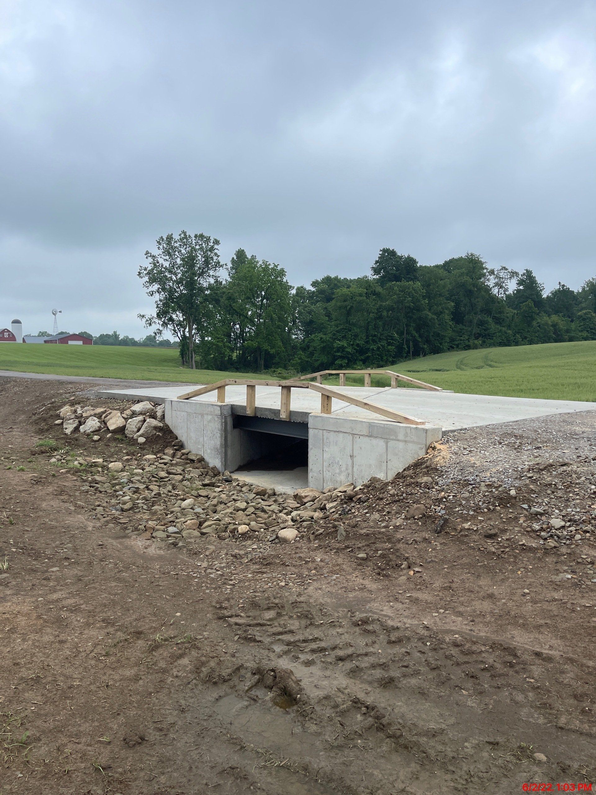 A concrete structure is being built in the middle of a dirt field.
