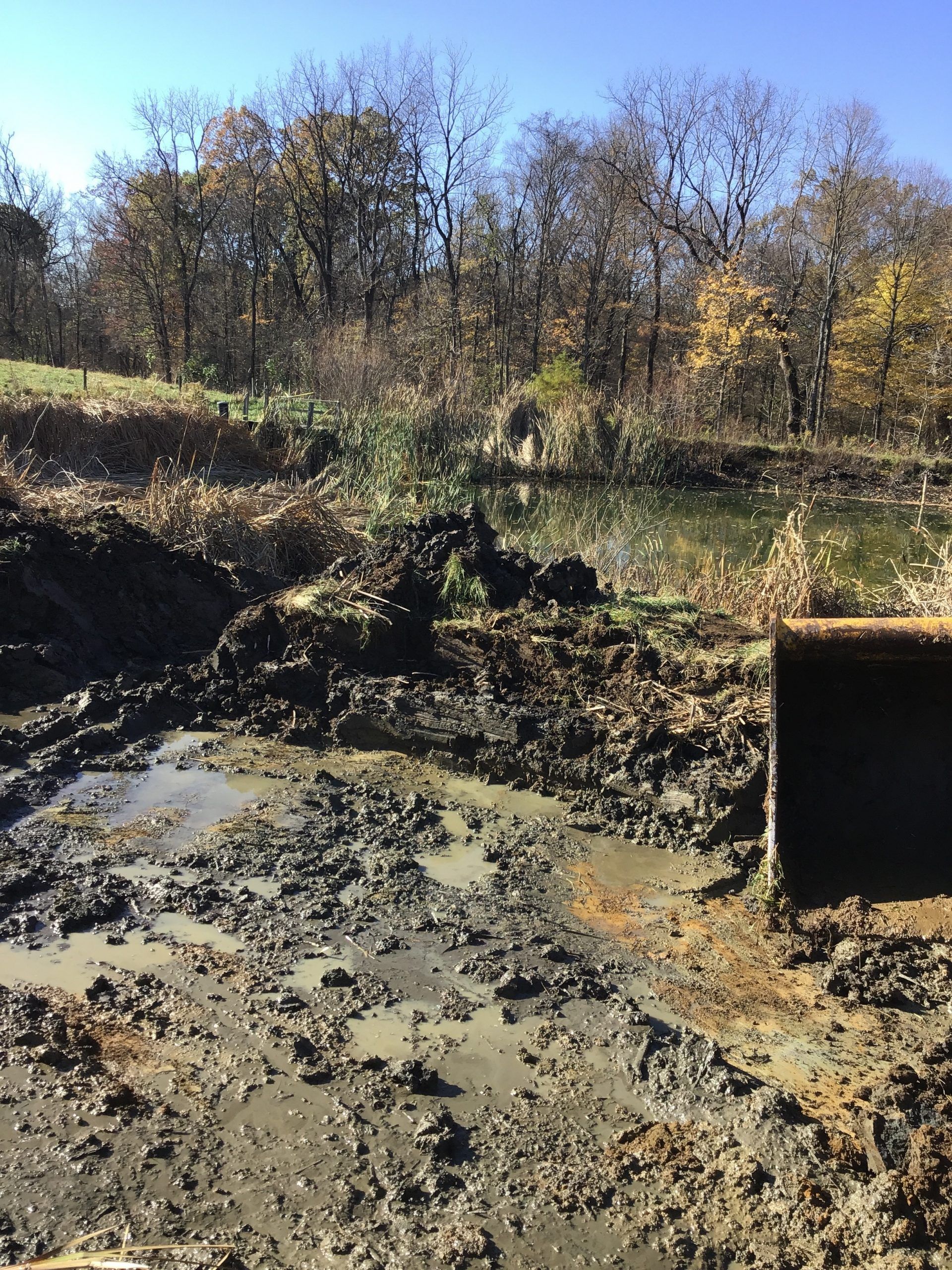 A large pile of dirt is sitting in the middle of a muddy field.