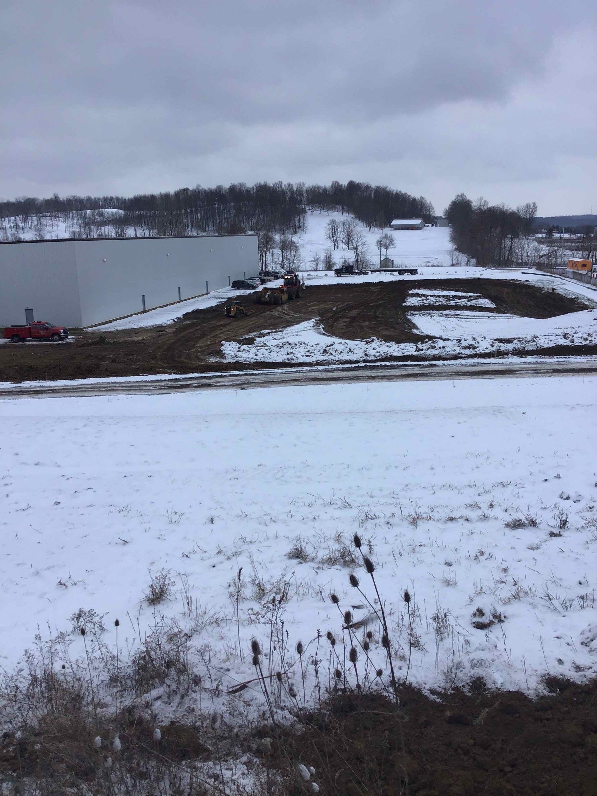 A snowy field with a building in the background