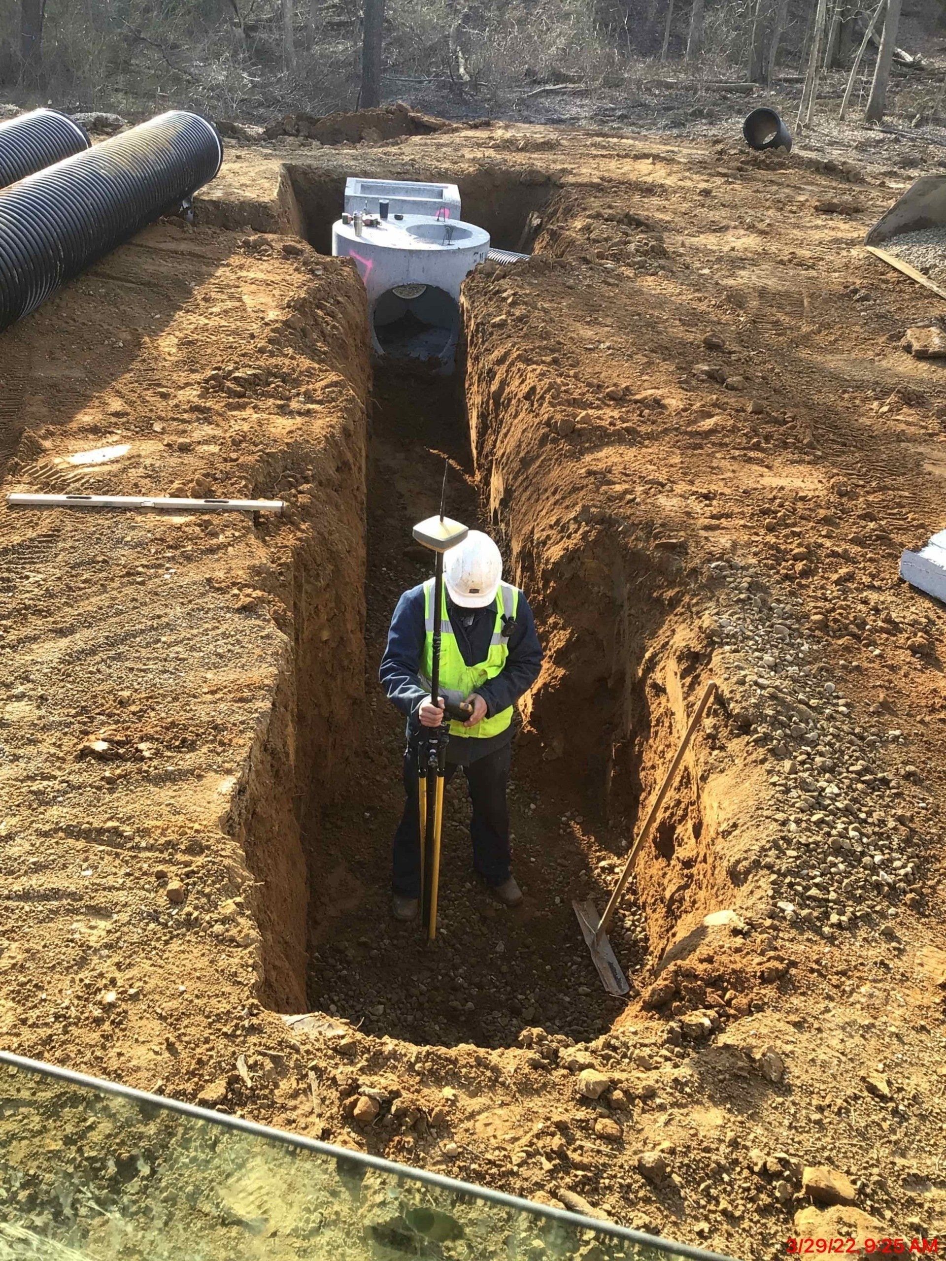 A man is digging a hole in the dirt with a shovel.
