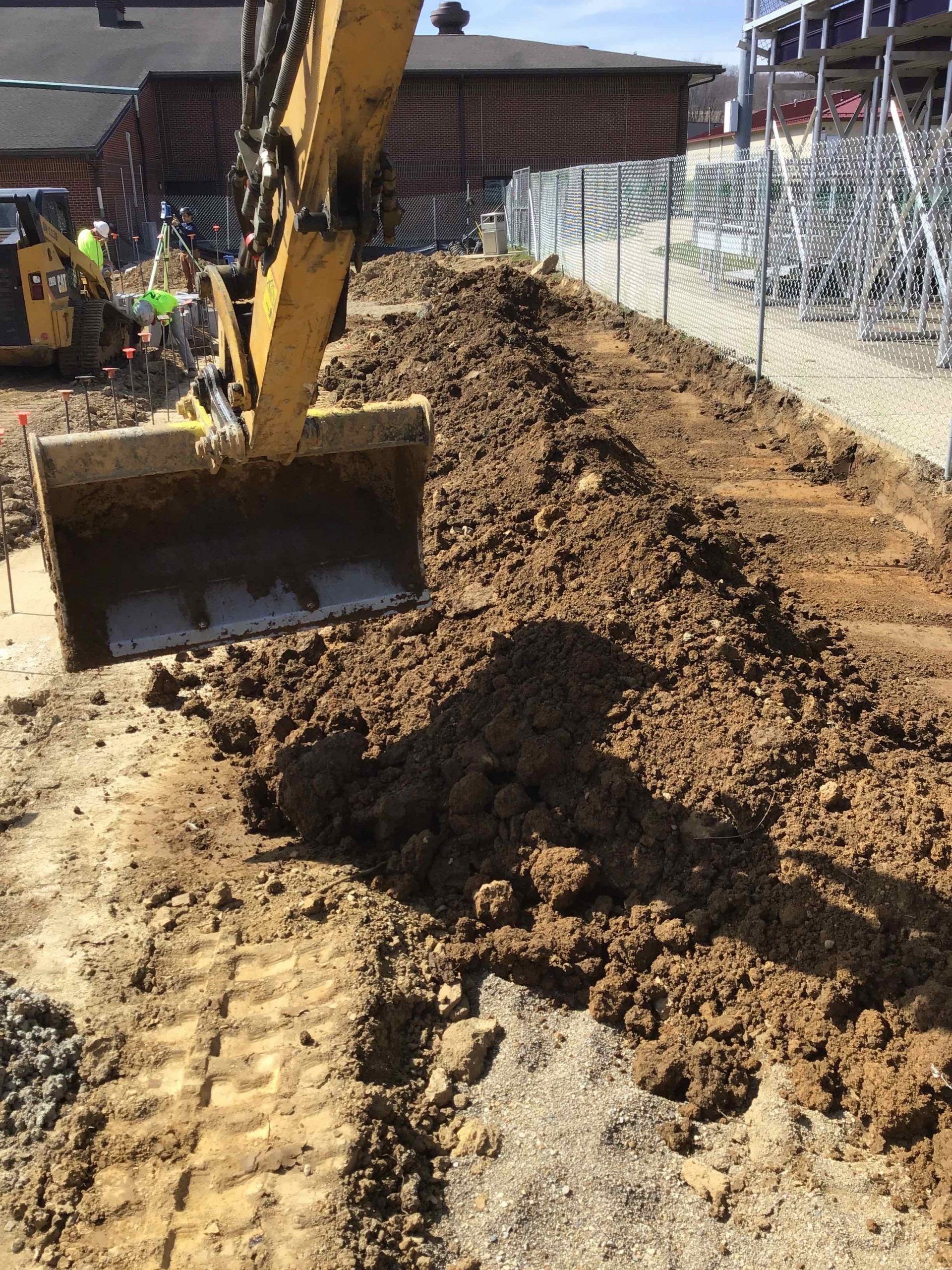 A bulldozer is digging a hole in the dirt on a construction site.