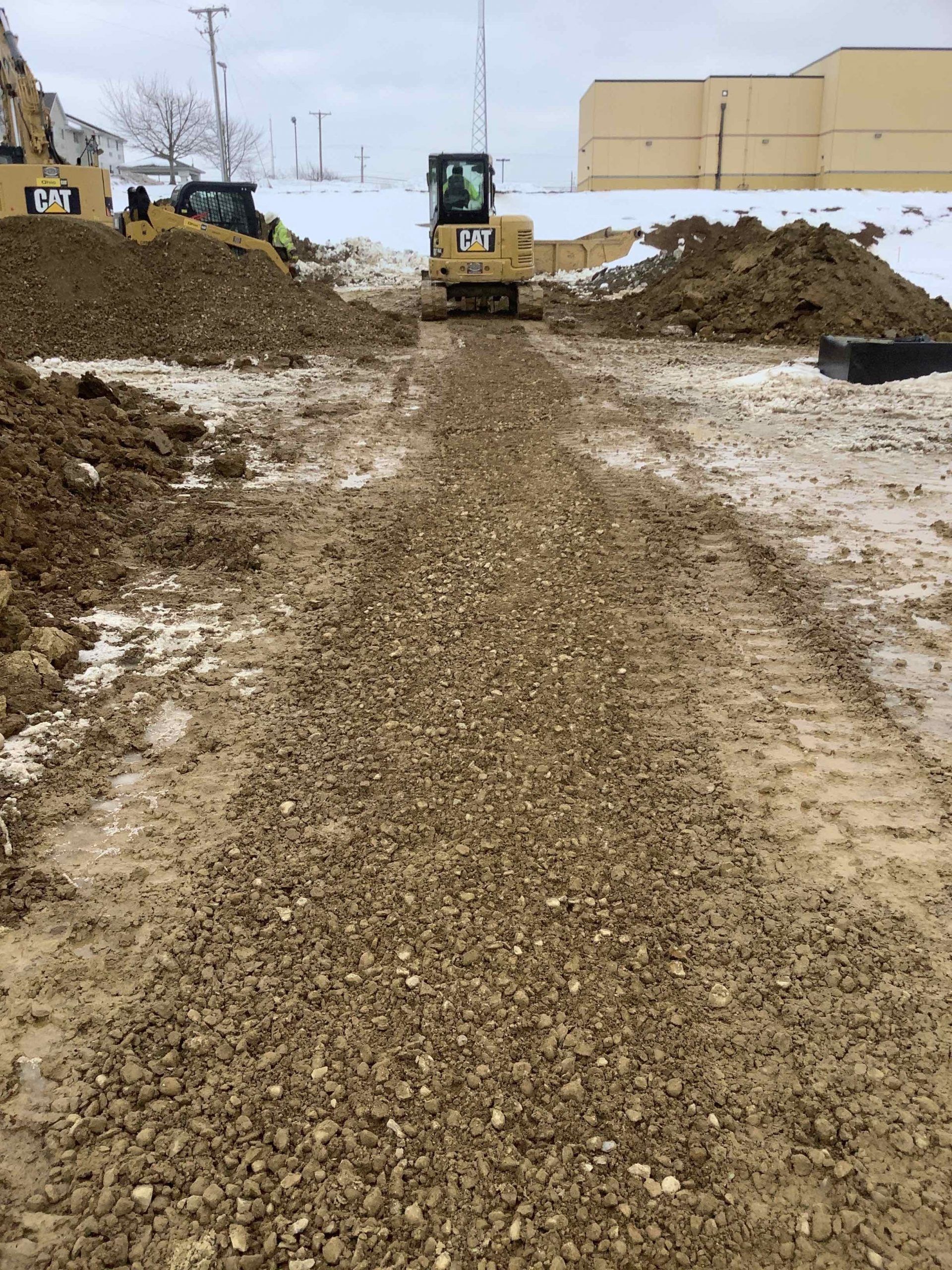 A bulldozer is driving down a dirt road.