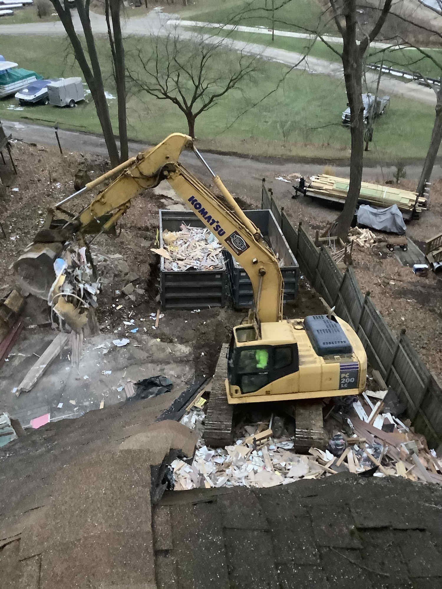 A large yellow excavator is working on a construction site.
