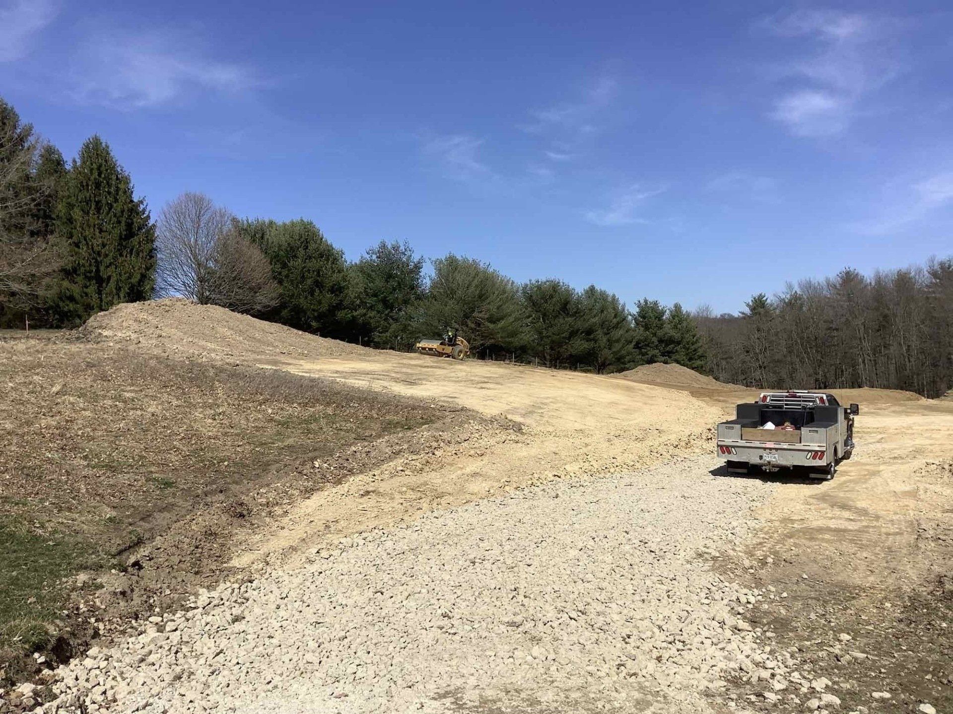 A truck is parked on the side of a dirt road.