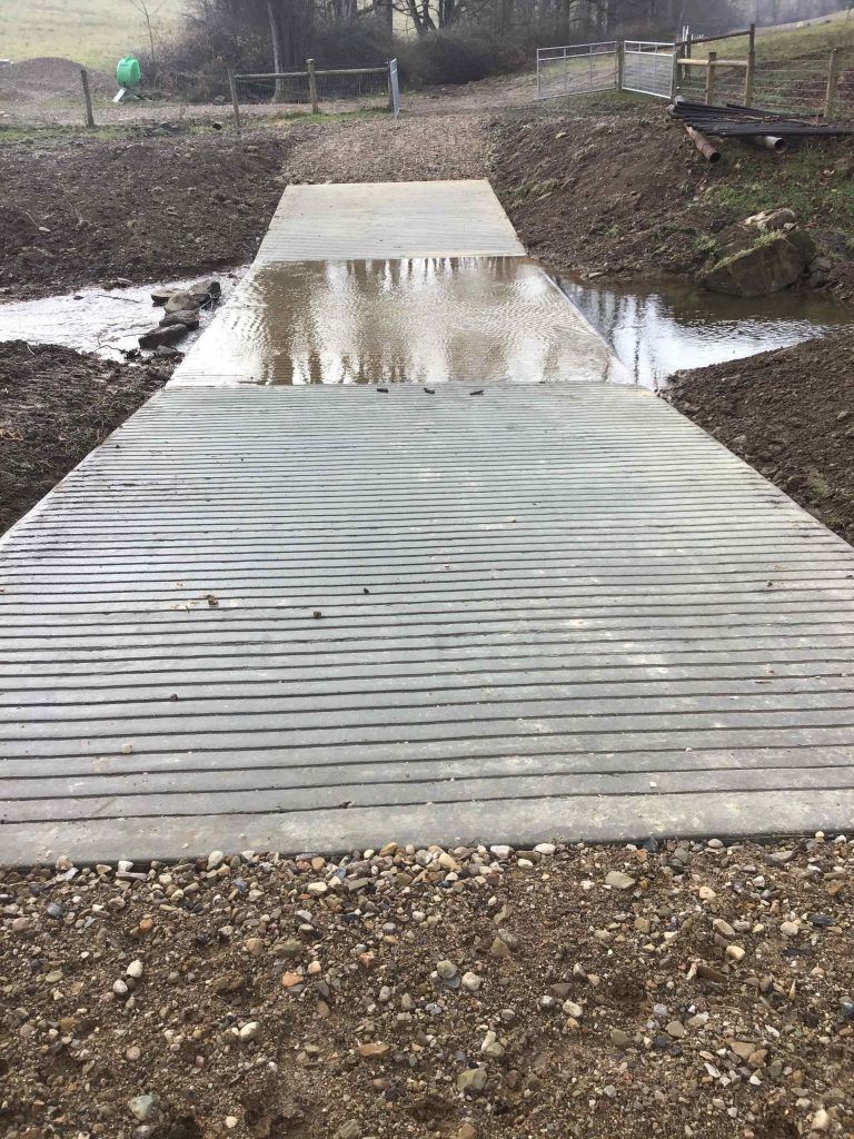 A concrete walkway leading to a body of water.