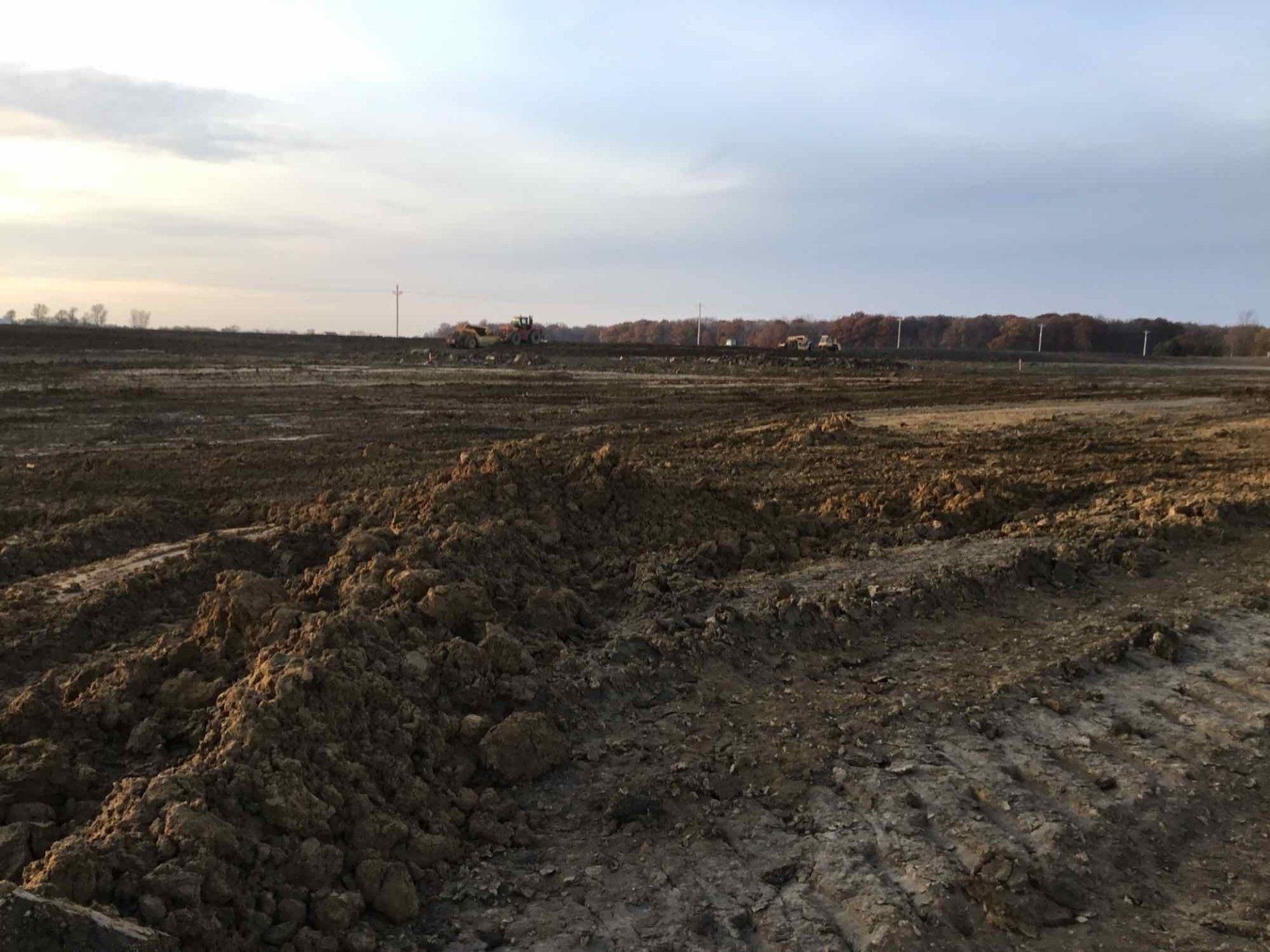 A large pile of dirt is sitting in the middle of a field.