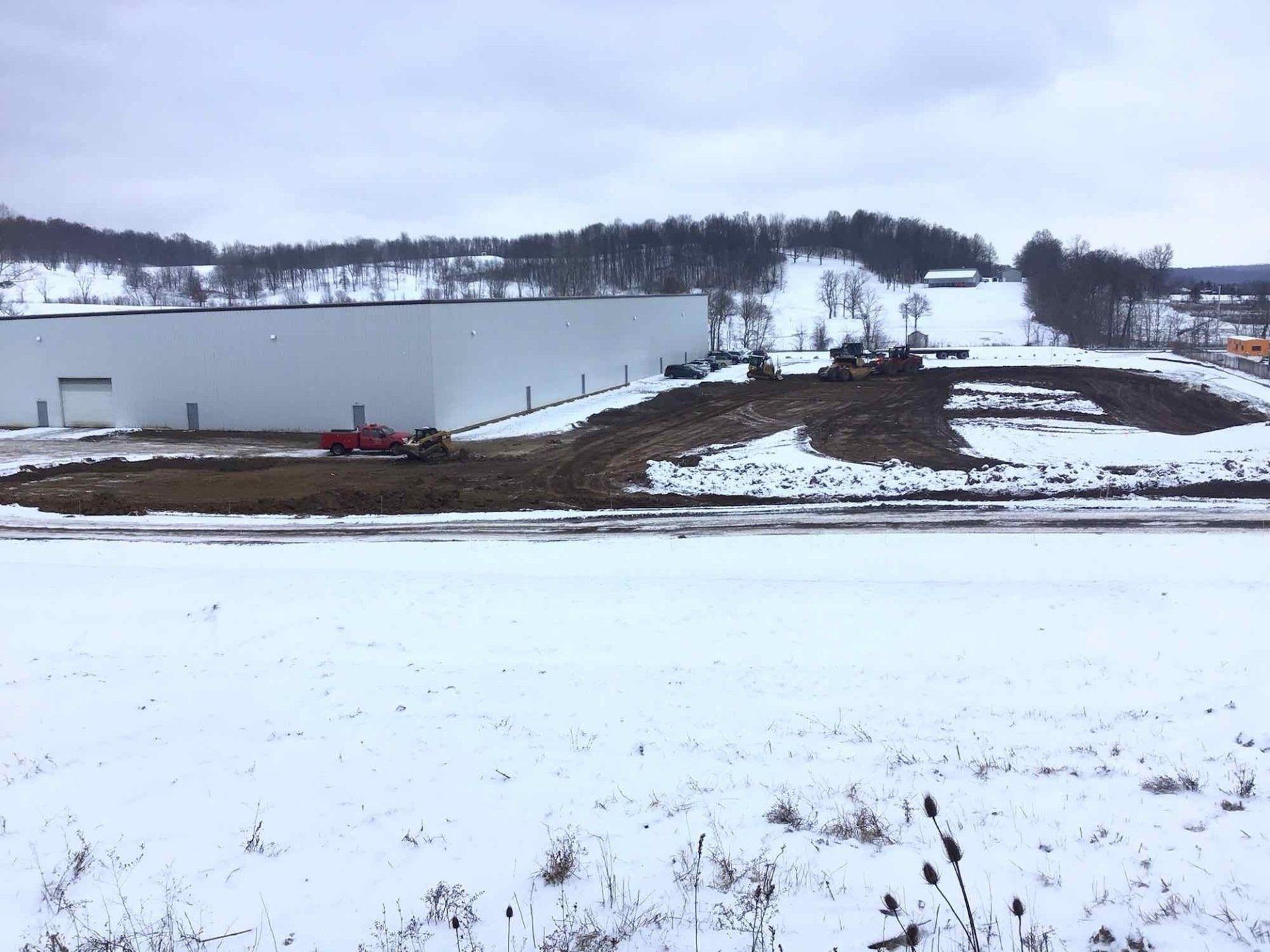 A snowy field with a building in the background
