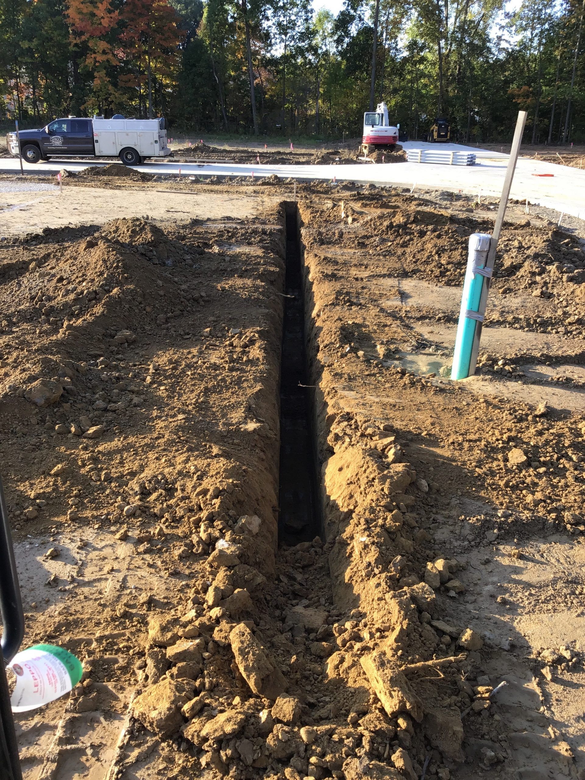 A pipe is being installed in the dirt on a construction site.