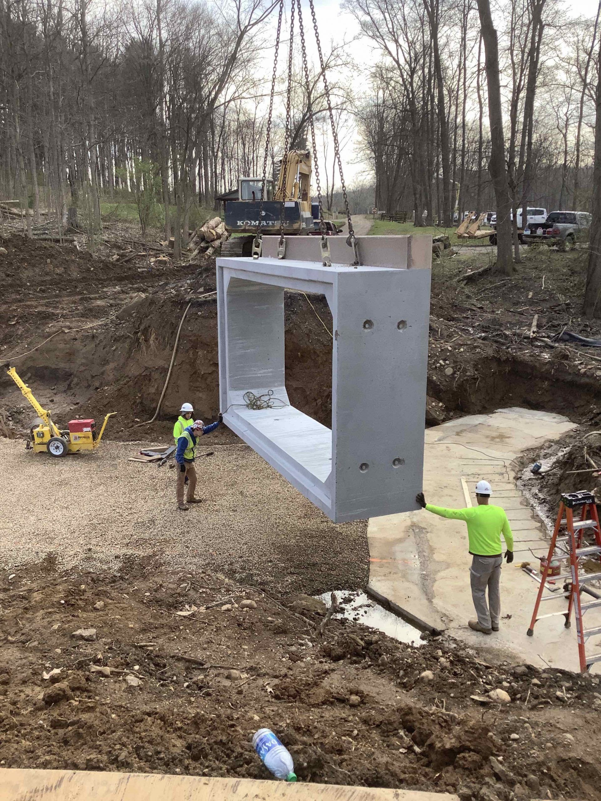 A large piece of concrete is being lifted by a crane.