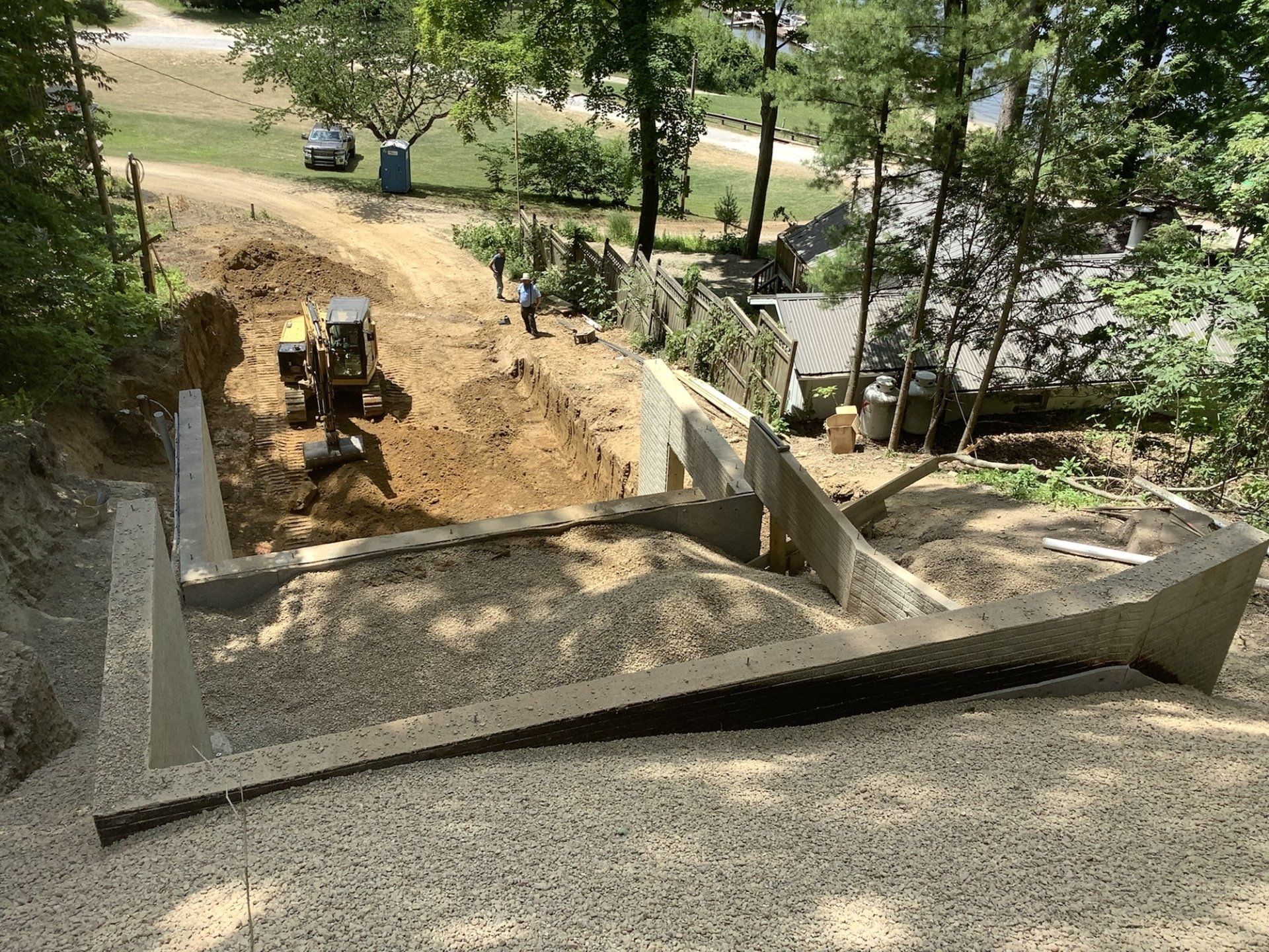A concrete ramp is being built on top of a dirt hill.