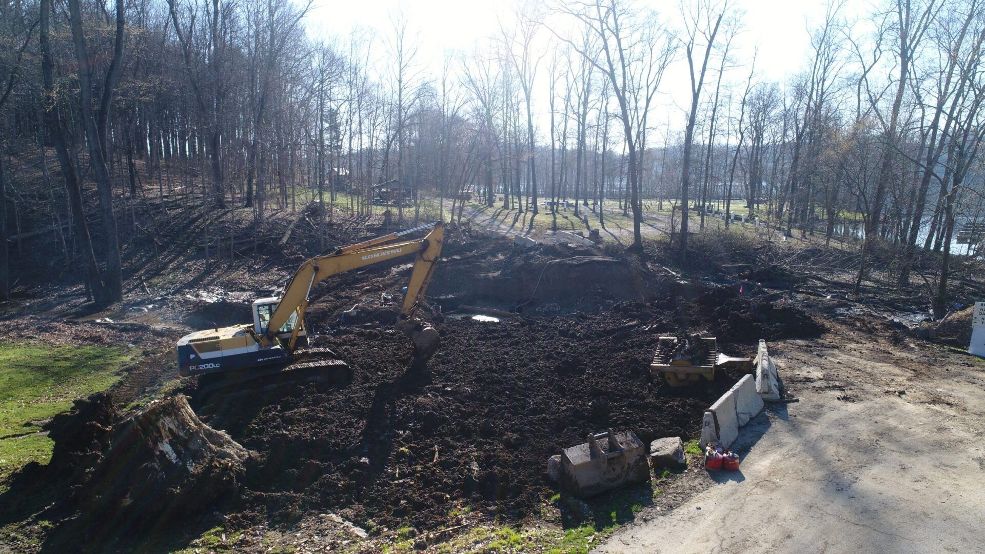 A large excavator is moving dirt in a field
