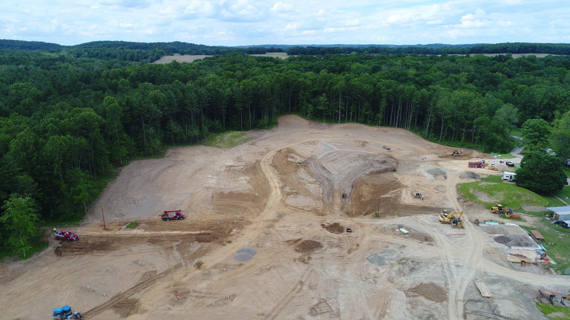 An aerial view of a construction site in the middle of a forest.