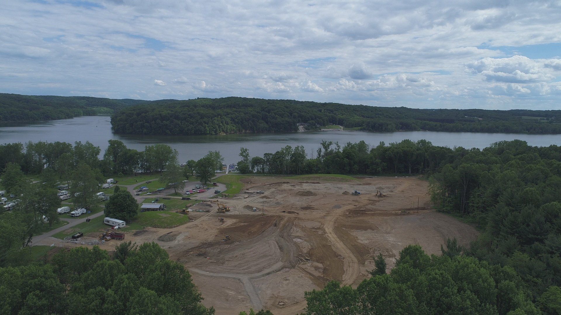 An aerial view of a large body of water surrounded by trees and dirt.