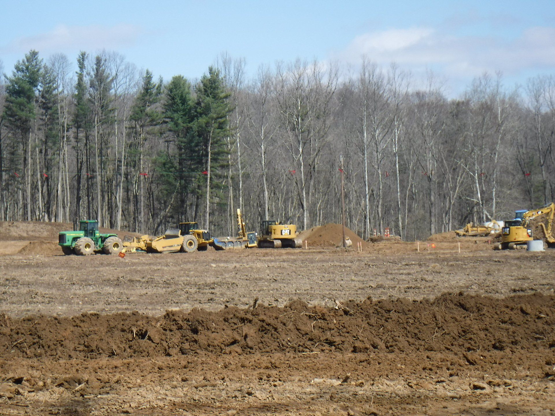 A construction site with a lot of dirt and trees in the background