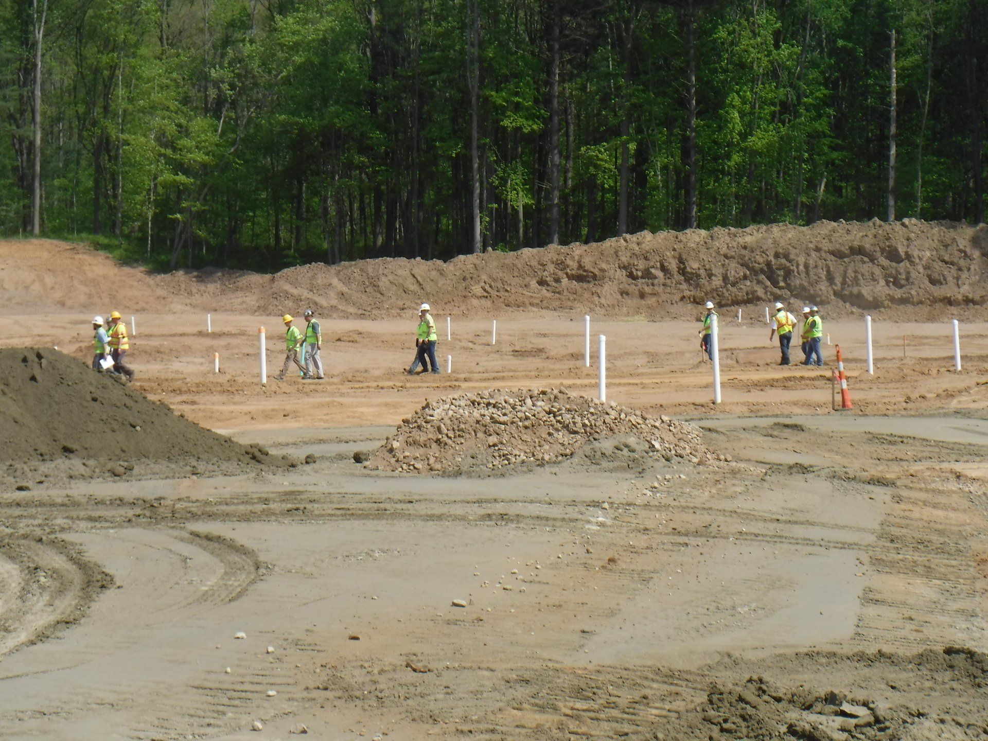A group of construction workers are working on a dirt field