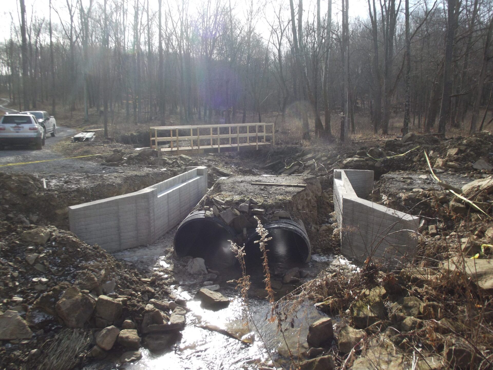 A bridge is being built over a stream in the woods