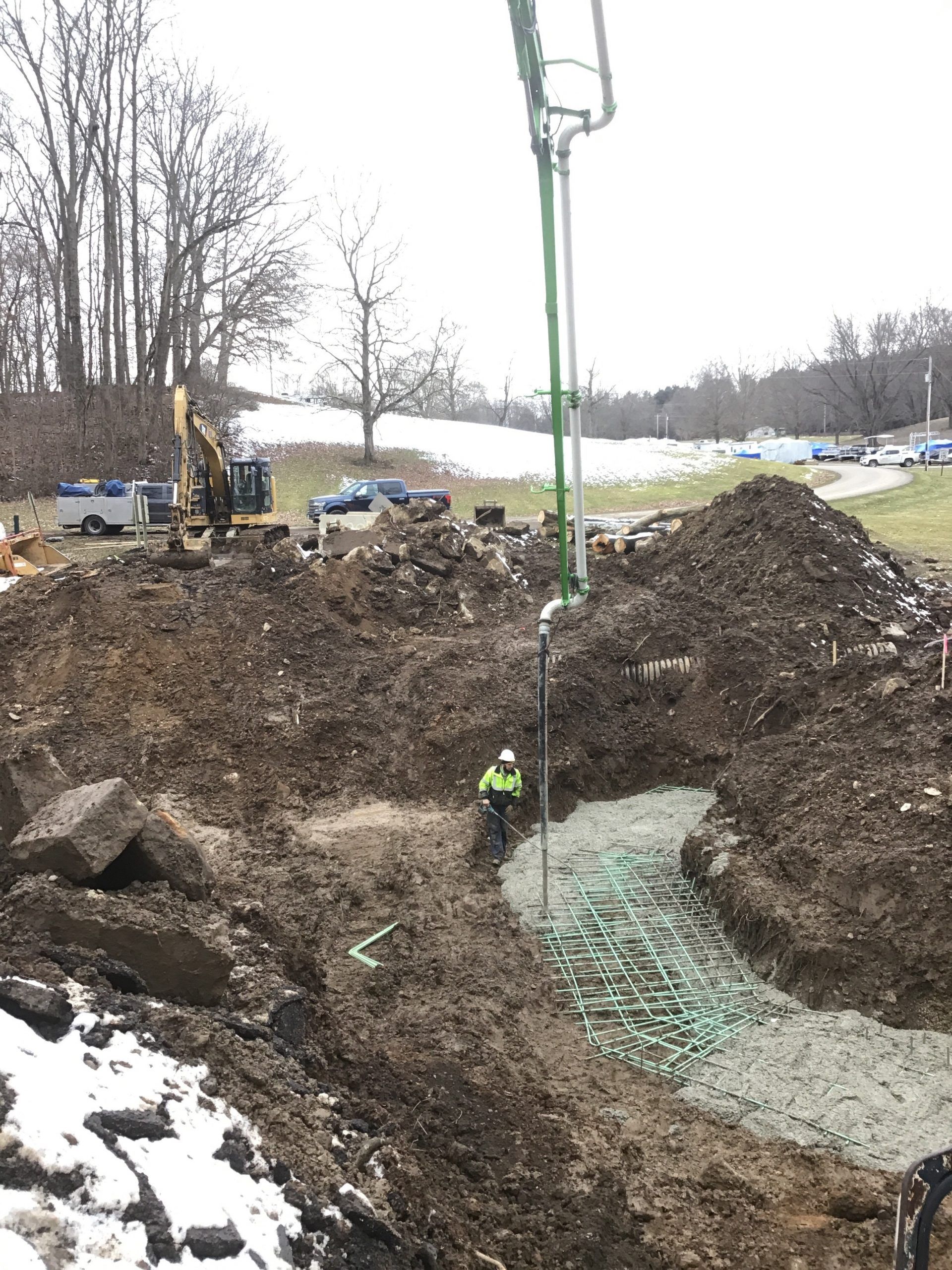 A man is standing in the middle of a large pile of dirt.