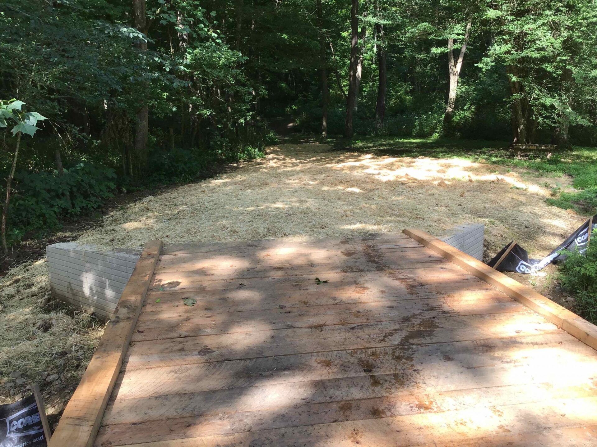 A wooden bridge is being built in the middle of a forest.