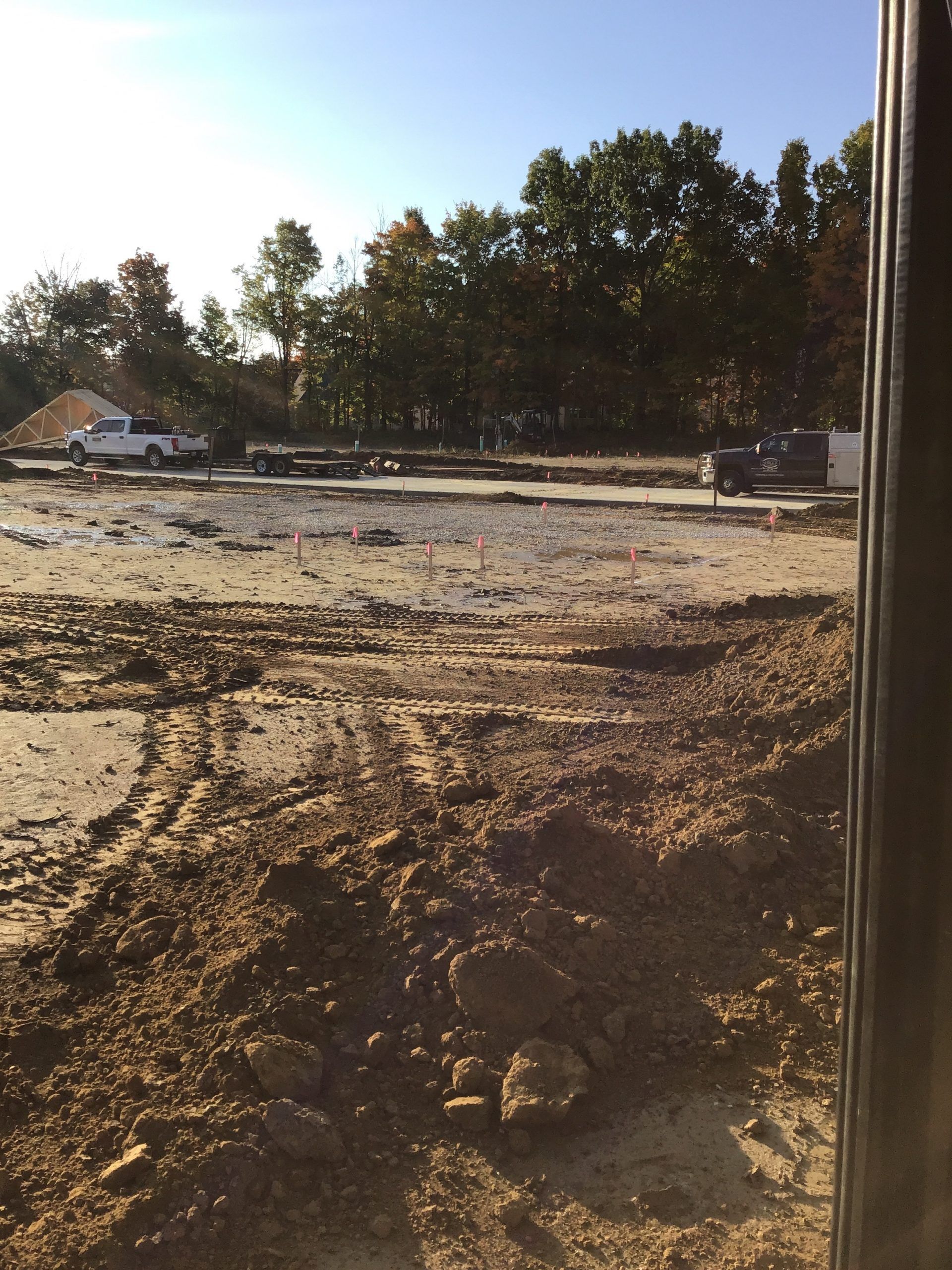 A construction site with a lot of dirt and trees in the background