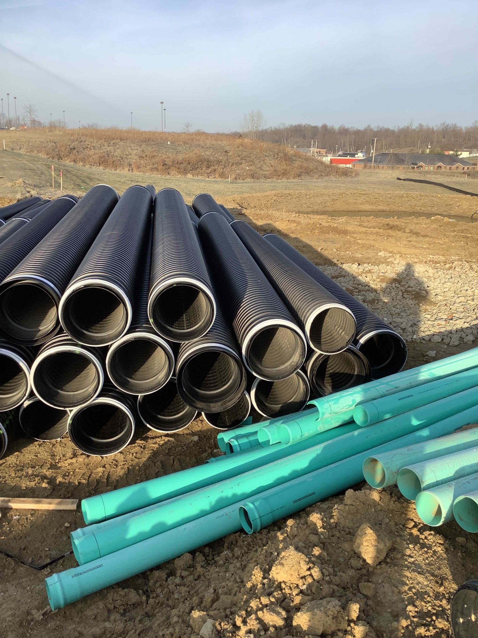 A pile of pipes sitting on top of a dirt field.