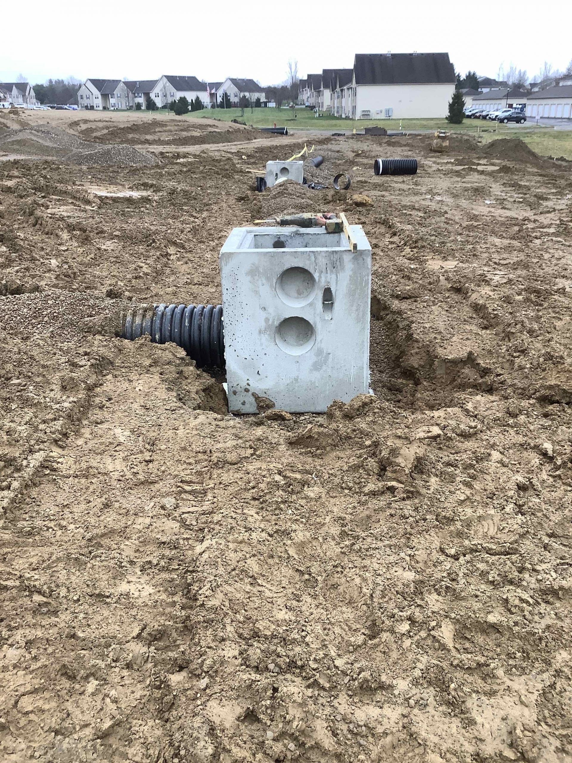 A concrete box is sitting in the middle of a dirt field.