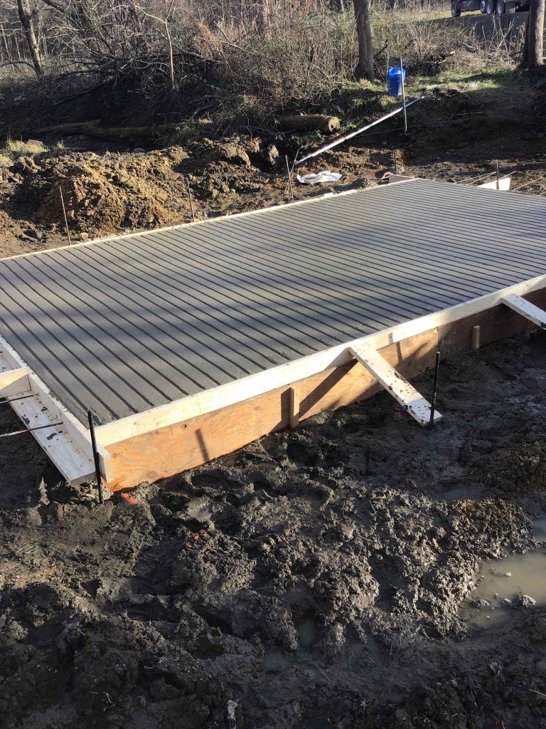 A concrete slab is sitting on top of a muddy field.