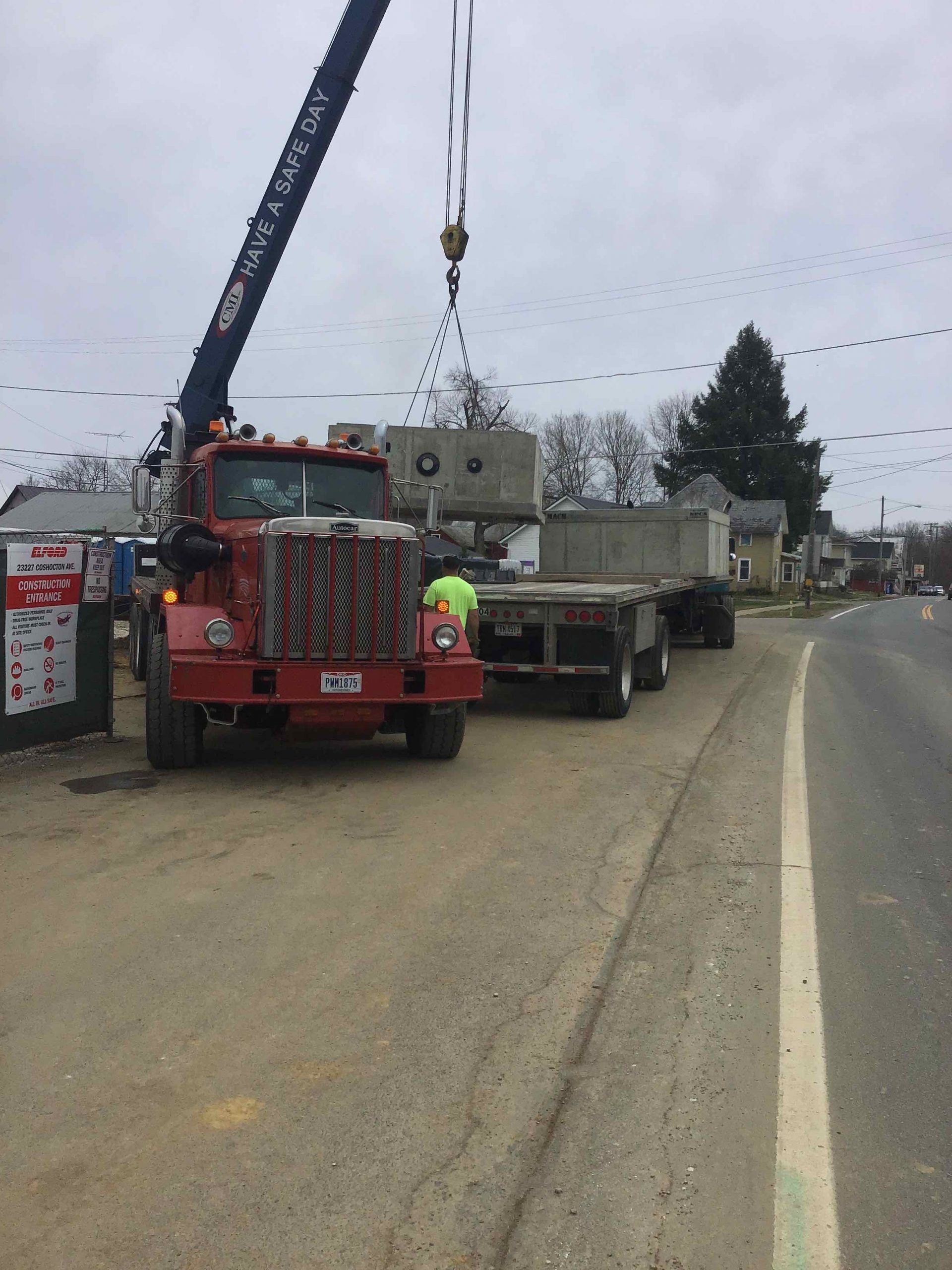 A red semi truck with a crane attached to it